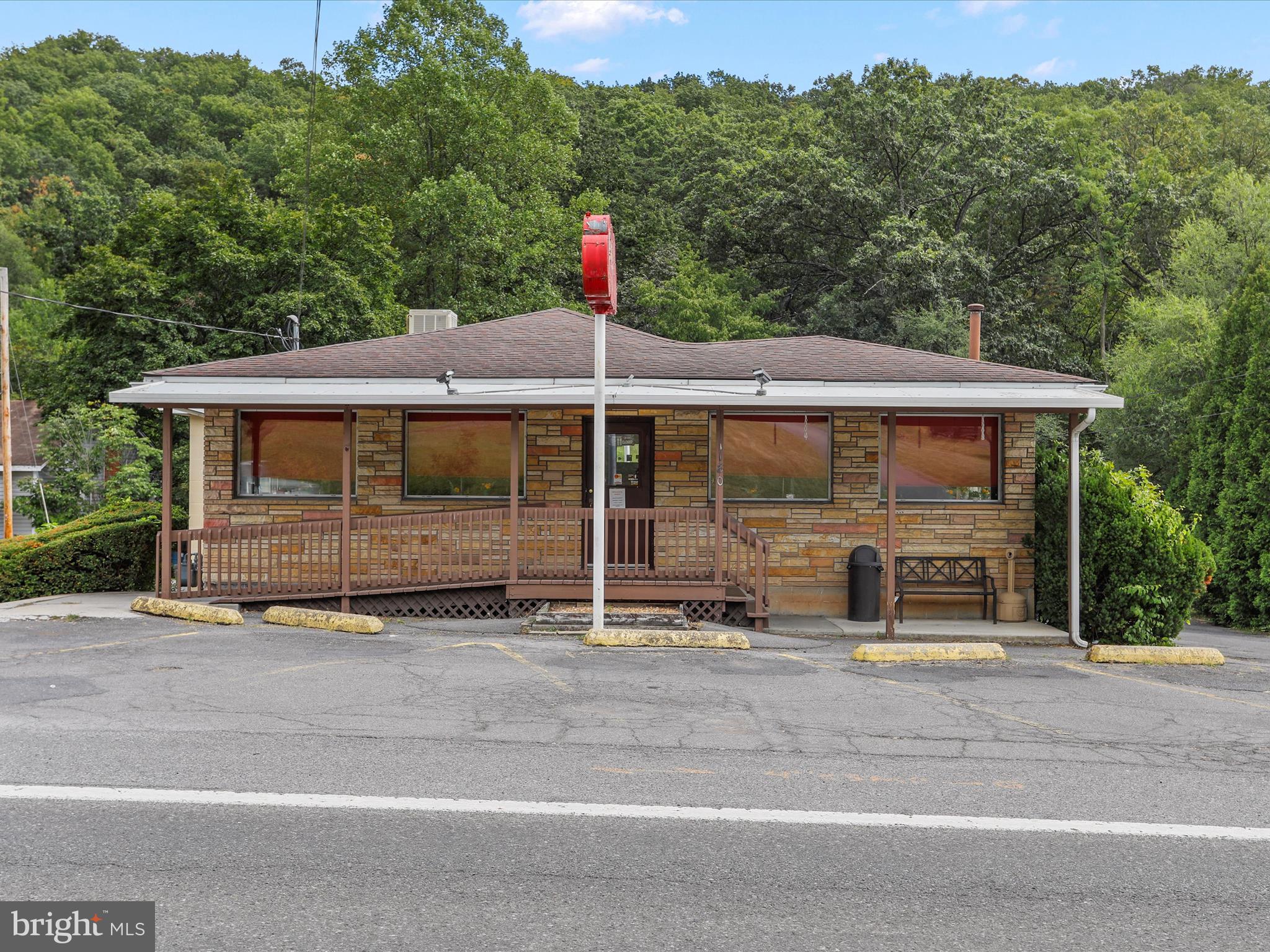 Great location; just off of Interstate 68! Currently a fully functioning restaurant with a 3bedroom plus a living room that comprise living quarters. There's a bathroom attached to bedroom #2. No kitchen in living quarters. Downstairs has a 2nd apartment (1 bedroom) with a kitchen. Two car carport plus a detached 2 car garage with an attached storage shed. Parking for 20 plus cars! Ramp for easy entry to restaurant! Entrepreneurs, bring your ideas for this space. Please note: surveillance cameras in use.