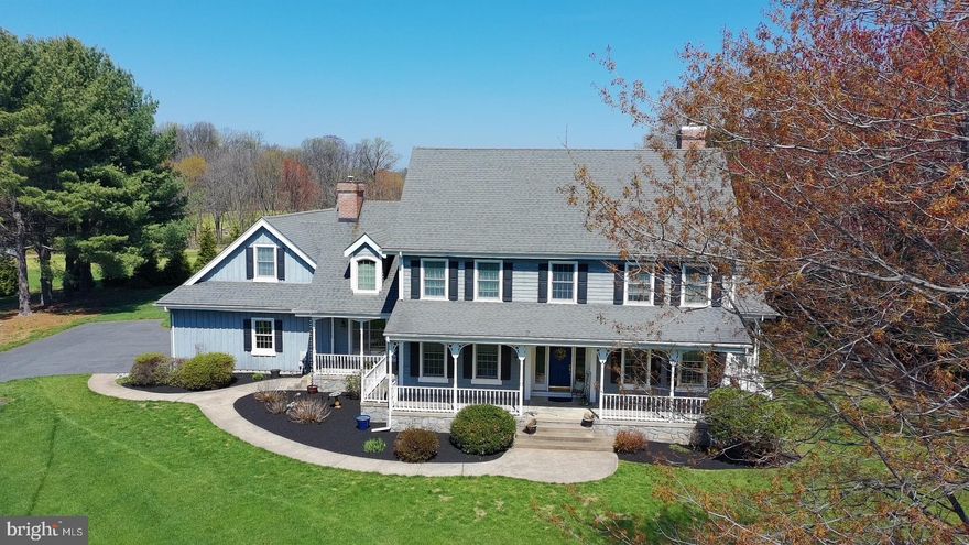 Nestled against a picturesque 21-acre farm, this Wilkinson-built colonial sits on a beautiful, flat 1-acre lot offering both space and privacy. The home has been thoughtfully updated over the years, including a new roof (2012), HVAC system (2018), well pump (2025), updated kitchen, and a newer full bath on the first floor. All windows were replaced in 2005.

Boasting 4–5 bedrooms and 3.1 bathrooms, this property also features a charming wraparound porch, an in-ground pool, and scenic open land views. Upon entry, you’re welcomed by a dramatic two-story foyer and stunning random-width hickory hardwood flooring that flows throughout the main level.

The spacious living and dining rooms provide ideal areas for entertaining. The inviting family room includes a wood-burning fireplace and sliding glass doors that open to a large deck overlooking the pool—perfect for indoor-outdoor living.

The updated kitchen is well-appointed with stainless steel appliances, recessed lighting, granite countertops, a large island, and a generously sized pantry. The adjoining eat-in area features a cozy gas fireplace with a brick surround.

A large laundry room with a full bath connects to the oversized three-car garage. A rear staircase leads to an expansive bonus room above the garage—ideal as a fifth bedroom, playroom, or media space.

The primary suite offers a vaulted ceiling with fan, a walk-in closet, and a spacious en-suite bath complete with dual marble vanities, a stall shower, jetted tub, and recessed lighting. Three additional bedrooms and a full hall bath complete the second floor.

The basement provides abundant storage and offers great potential for future finishing. With minimal updates, this home presents an incredible opportunity to create your dream space in a serene setting.