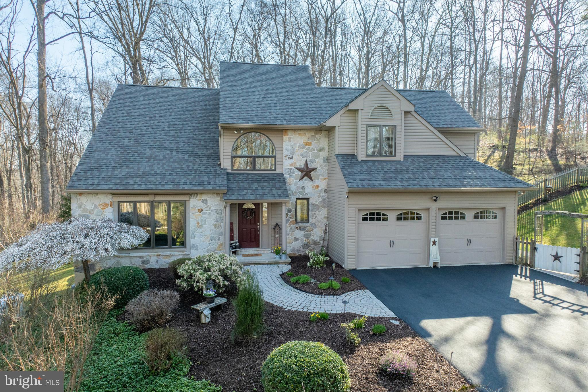 Chester Springs Panache! An inviting style, a scenic grace--indoors and out. Welcome to a 3+ acre, tree-embraced haven in the custom home enclave of Hickory Hill. Follow the graceful drive to the entrancing, nature-tinted residence surrounded by enchanting landscaping. Find your outdoor bliss, stepping from patio to patio to deck, enjoying the gurgling waterfall and garden pond, relaxing in the hot tub or entertaining a crowd. (Beautiful in the day and evening--note the evening landscape lighting photos!) Nearby historic Horseshoe Trail beckons walkers and runners alike--a one-of-a-kind tour of nature! The contemporary farmhouse design has an airy, open interior flow highlighted by designer windows and volume ceilings. Enter the 2 story foyer embellished with gleaming hardwoods and pretty moldings. The eye-catching living room, boasting high ceiling and abundant windows, is not a shy hideaway--it's meant to be used! The delectable dining room with gleaming hardwood floors connects the living room and heart-of-the-home kitchen--perfect floor plan for everyday life and easy entertaining.  Statement-making amenities fill the  richly appointed eat-in kitchen-from elegant cabinetry, to beautiful stone counters and backsplash, to polished wood floors! The dining bar overhang and well-lit breakfast area make the perfect casual eating spots! Step right into the striking, sky-lit family with vaulted ceiling and rugged, floor-to-ceiling stone fireplace--a comfortable cocoon! A sleek powder room and efficient laundry room complete the first floor. A spacious primary suite graces the serene second floor, It boasts a walk-in closet and chic, well-appointed, primary bath dressed in warm, neutral tones, Three additional, bedrooms and full hall bath complete this pretty level.( Bedrooms 3 and 4 have had a wall opened to create an open sitting suite for current occupant's use.) The expansive, walk-out lower level awaits your creative finish for more space!  Quintessential Chester County living at its finest!