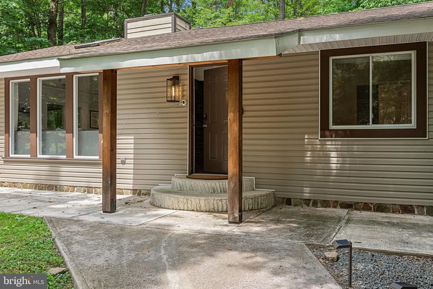 Discover your perfect getaway in the heart of the Poconos! This turnkey 4-bed, 2-bath home in the desirable Greenwood Acres community blends rustic charm with modern style and an open floorplan ideal for relaxing or entertaining.  Enjoy a spacious living room with high ceilings, a stone fireplace, skylight, and parquet flooring.  The updated kitchen features modern appliances, bar-top seating, and flows into the dining area.  Sliders lead to a covered patio with cozy outdoor seating and string lights.  The main level includes 2 bedrooms and a full bath, while the lower level offers 2 more rooms, a second bath, a hangout space, and laundry.  The garage doubles as a fun game room!  Stay comfortable year-round with mini split systems and enjoy the modern mountain aesthetic throughout.  Outside, unwind around the private firepit or explore community amenities like the lake, beach, and playgrounds.  Just minutes from skiing, hiking, and shopping!  Whether you're looking for a full-time residence, a weekend getaway, or short-term rental (currently operates as a popular STR), this home checks every box!