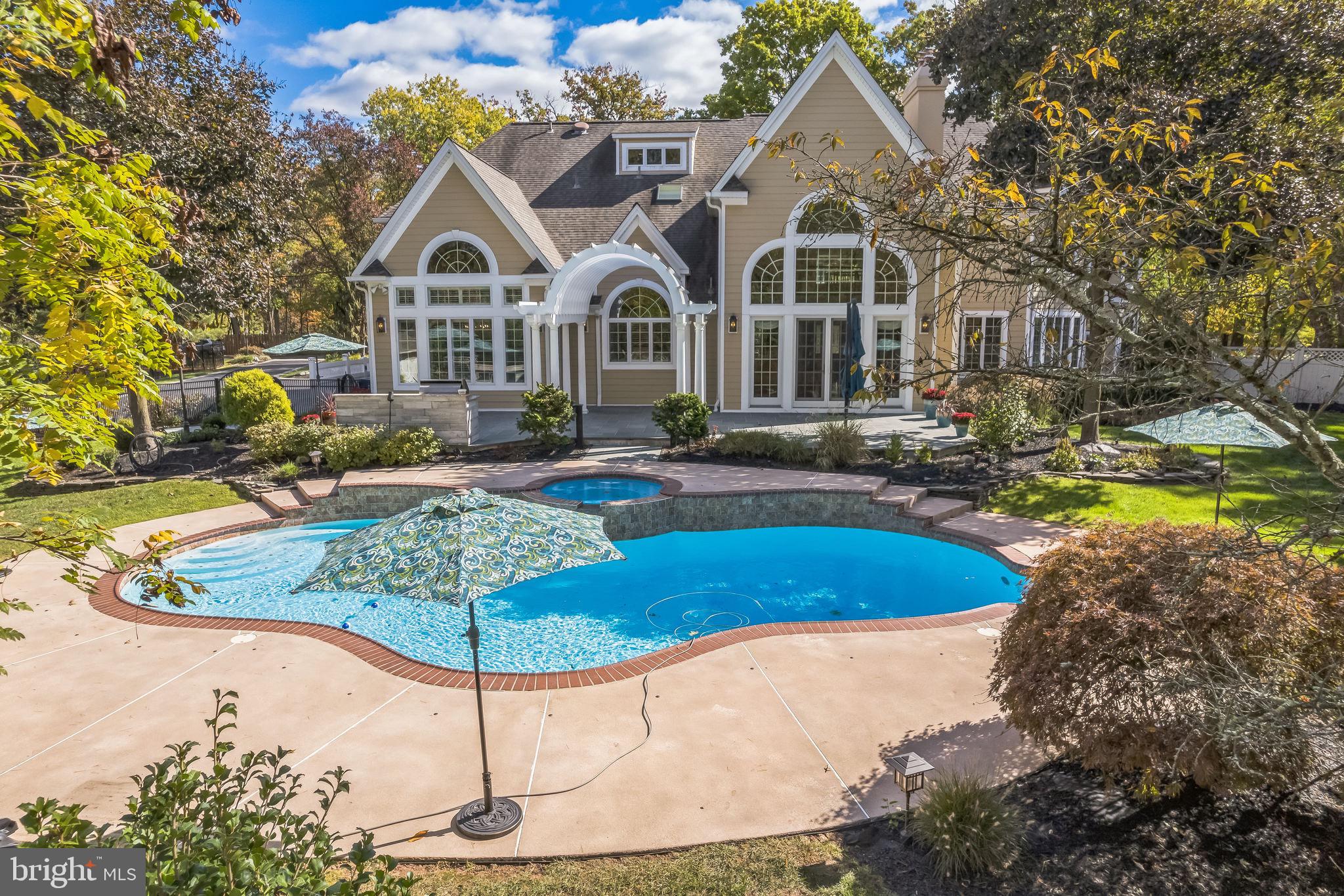 Price improvement - this remarkable 4-bedroom, 5.5-bath home on one of Lower Gwynedd's most desirable streets is a true gem. Nestled on lushly landscaped grounds with mature trees and vibrant plantings, the property combines privacy with sophistication. Enter through impressive double doors into a bright foyer featuring a grand chandelier, marble flooring, and a sweeping curved staircase. The open layout showcases exceptional craftsmanship, with custom millwork and built-in shelving throughout.
The light-filled living room, with its cozy fireplace, offers ample space for gatherings, while the refined dining area—with tray ceilings and large windows—is ideal for hosting. A spacious office, featuring custom woodwork and tranquil backyard views, provides an inspiring workspace. The gourmet kitchen boasts high-end stainless steel appliances, custom cabinetry, under-cabinet lighting, and a large island for casual meals, flowing seamlessly into a character-rich family room. A mudroom, laundry area, and powder room complete the main floor. Recently refinished wood floors, new carpeting upstairs, and freshly painted rooms in neutral hues make this home move-in ready.
The primary suite upstairs features a spa-like bath and a custom walk-in closet. A secondary suite, complete with two walk-in closets and a private bath, along with two more bedrooms with en-suite baths, provide both comfort and privacy. A bonus room on the third floor offers the option for a fifth bedroom. The spacious finished basement includes a gym, a full bath, a fireplace, and abundant entertainment space.
The secluded backyard is a true retreat, featuring a heated gunite pool, spa, and an expansive bluestone patio equipped with a premium Twin Eagle outdoor kitchen and sound system—ideal for outdoor living and entertaining.
This home is equipped with a generator, water softener, radon remediation system, Sonos sound system, custom window treatments, four zones for temperature control, flood lighting, and a security system. The heated three-car garage includes an EV charger.
Meticulously maintained and move-in ready, this home offers convenient access to major roads, shopping, dining, Whole Foods, and train stations for an easy commute to Philadelphia. Situated in the highly sought-after Wissahickon School District and close to esteemed private schools like Gwynedd Mercy and Germantown Academy, this exceptional property is ready to be yours. Schedule your viewing today!