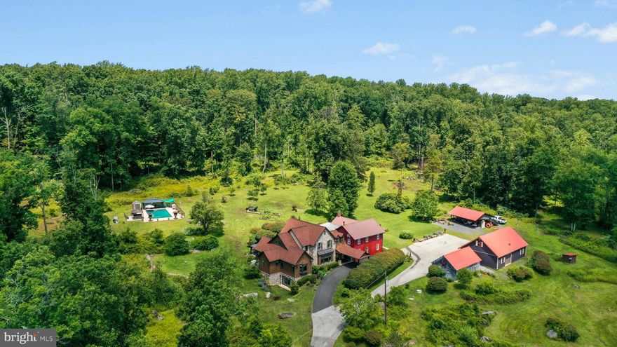 Set at the end of a long gated driveway amidst 65 open and wooded acres Boulder Ridge Farm has been reimagined into a rare multi-generational compound where 1890s Bucks County history and the 21st century blend harmoniously. A fully individual 3 to 4 bedroom home with all the modern conveniences was masterfully crafted in 2019 by Monogram Custom Homes and attached to the original classic 5 bedroom Bucks County farmhouse to create dual homes that are perfect for families who want separate spaces but proximity.  Floorplans available at https://my.homediary.com/story/484610/u
     The ultra-efficient modern home has been crafted with an eye for detail and extraordinary building practices. A two story foyer flows into an open floor plan framed by detailed moldings and heated wood floors. The heart of the home is a stunning kitchen with granite countertops, walk-in pantry, island and side by side Wolf induction ranges with copper pot filler. Additionally, a built-in Miele coffee station, Fisher and Paykel dishwasher drawer and SubZero refrigerator ensure the chef will have all amenities at their disposal.
     Steps away from the kitchen is an elegant great room with coffered ceilings, triple window with built-in bench seat, gas fireplace flanked by floor-to-ceiling cabinetry and display shelving. A dining room also enjoys heated wood floors. The adjacent sun/sitting room has a vaulted ceiling with skylights, a picture window and glass doors to the bluestone patio.
     This home has a sought after main floor primary suite and 2nd bedroom or office. The walk-in closet is outfitted with beautifully crafted custom wood cabinetry and built-ins. A spa bath luxuriously accommodates with a jetted tub, separate granite vanities and water closet, all with heated floors and decadent heated river rock shower floors. The second floor loft hang-out area opens to two large bedrooms with walk-in closets and Jack and Jill bath with granite vanity and double sinks.
     A walkout lower level, also with heated floors, will continue to amaze with media, game, exercise, and family spaces. A beautifully appointed kitchenette has granite counters, high-end appliances and bar seating, with a full bath just beyond. Glass doors lead to the lawns and outdoor amenities.
     Not to be outshown by its modern counterpart the adjacent antique farmhouse also has an open and expansive floor plan. An updated kitchen features soft-close cabinetry and granite counters, and is open to the dining room, living room with fireplace and woodstove, and family room all with hardwood floors. The cozy den could also serve as a private home office. Five second floor bedrooms have wood floors and are brimming with charm, including a primary bedroom with en suite bathroom, and hall bath.
     Enjoy a perpetual private vacation at your own home. Resort-like amenities include a sunsplashed pool complex with a heated inground pool, luxurious hot tub with gazebo, and cabana. A picturesque pond is surrounded by scenic overlooks including a hidden cabin, dock and gazebo, all private and perfectly placed for reflection and repose.  
     A detached oversized 3-car garage has a large second floor storage loft. An equipment garage and pavilion will house tractors and toys and a chicken coop is ready for your family’s flock.  
Escape from the ordinary and enjoy an exciting future in this versatile property located one hour from Center City Philadelphia.  Enjoy the best of Bucks County in a private and tranquil setting.