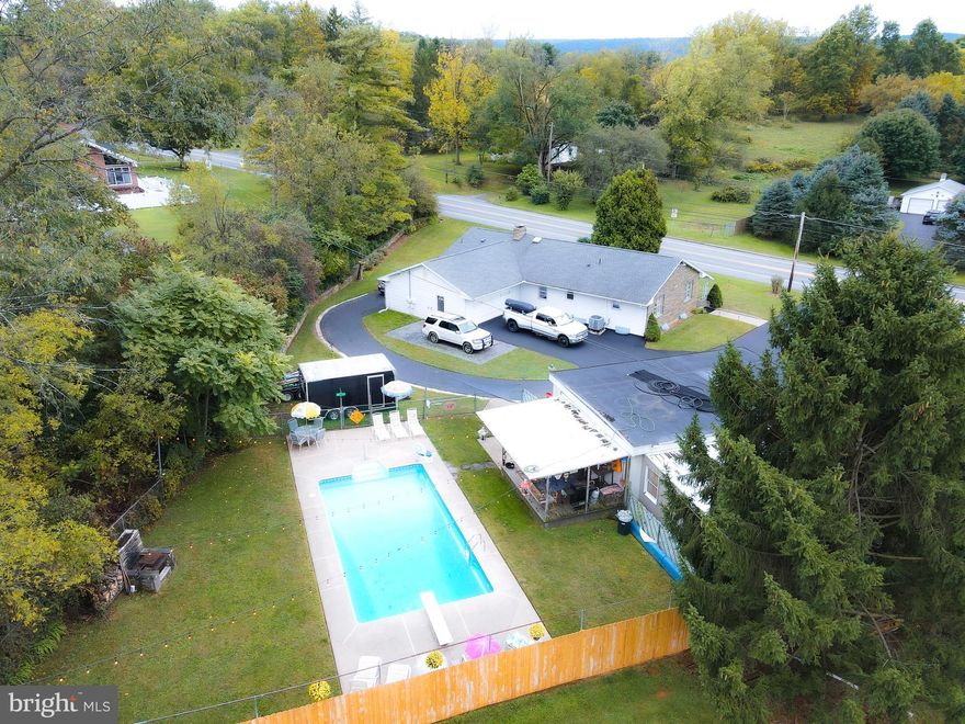 Welcome home to 1829 Zion Rd.  This charming ranch-style home boasts endless potential for any homeowner. The property features two fully finished levels, making it perfect for a multigenerational family seeking comfortable living spaces or savvy investors looking for appealing opportunities. Car enthusiasts will be pleased with the detached 3-car garage, mow shed, and attached heated 2-car garage with laundry area,  offering ample room for both storage and workshop activities. RV hookups outside of the attached garage too. The large eat-in kitchen and hardwood floors throughout the home exude comfort and warmth, creating a welcoming atmosphere throughout. Families will appreciate the cozy family room with a beautiful stone fireplace, ideal for gatherings and relaxation. With three spacious bedrooms conveniently situated on the same floor, this home is truly a haven for families looking for convenience.
Head down to the lower level through its own private entrace to see a full kitchen, full bath, laundry room, and two bedrooms.
Emerging back outside, a stunning oasis greets you with open arms. The in-ground pool shimmers invitingly, promising delightful moments of leisure and play. Adjacent, the covered porch provides a cozy escape from the sun, ideal for lounging and sharing stories with loved ones. And as daylight fades into evening, the fireplace casts a warm glow, setting the stage for unforgettable summer nights filled with laughter and happiness. Truly, this space is a sanctuary for creating cherished memories with family and friends.
All modern conveniences are just minutes away in Bellefonte ad State Colege making it a perfect blend of seclusion and accessibility.