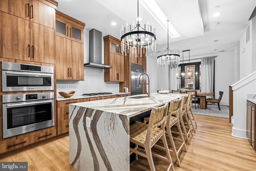 Welcome to luxury living at its finest in this nearly new, impeccably designed townhome in one of Rockville’s most sought-after communities, The Grove. Built in 2024 by award-winning Wormald Homes, this sophisticated residence blends thoughtful architecture, high-end finishes, and abundant natural light—delivering a lifestyle that feels both elevated and effortless.

Inside, soaring 10+ foot ceilings and wide-plank flooring set the tone for the main level, where open-concept living and dining spaces flow seamlessly. Floor-to-ceiling Sierra Pacific windows, finished in striking black, flood the home with natural light while adding a bold, modern edge. Just off the main living area, a private lanai offers the perfect setting for morning coffee or evening cocktails.

The gourmet kitchen is designed to impress, featuring premium Bosch appliances, upgraded cabinetry, sleek countertops, and an oversized quartz island that anchors the space. A custom-built bar enhances both functionality and style—ideal for entertaining or everyday living.

The entry level offers a versatile flex space perfect for a home office, gym, or guest suite, along with a powder room, mudroom, and access to a two-car garage. Upstairs, the primary suite provides a peaceful retreat with dual closets and a spa-inspired en-suite bath. Two additional bedrooms, a full bath, and a spacious laundry area complete the upper level.

Each level of the home offers its own unique space to relax and recharge, from private outdoor areas to thoughtfully designed interiors—creating a seamless balance of comfort and connection throughout.

Located in the highly regarded Wootton School District, residents enjoy access to exceptional community amenities, including a clubhouse with a gym and pool, walking trails, sports fields, playground, and dog park. You’re just minutes from shopping, dining, and entertainment at Traville Gateway, Fallsgrove, Downtown Crown, Rio, and Kentlands, with convenient access to I-270, the BioMed Corridor, Shady Grove Hospital, AstraZeneca, and the Shady Grove Metro.

Move-in ready and better than new, this home offers the rare opportunity to enjoy modern luxury without the wait. Just unpack and start living.
Mortgage savings may be available for buyers of this listing.