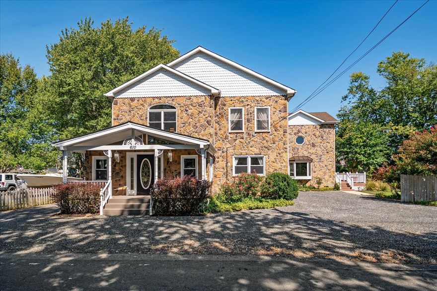 The Very Best Deal in Deale!! This home has it all! TONS of space, Not just one but TWO main level bedrooms, a detached garage for the hobbyist, gorgeous modern updates throughout and it's located just a quick one minute walk to the best boating, fishing and swimming on the Bay!—This HUGE home is just 1 block from the water and priced well below market value!! Seller is highly motivated! Make an offer! This expansive custom-built move-in ready home offers exceptional space, charm, and lifestyle in the sought-after water-access community of Owings Beach. From the handsome stone façade and tranquil gardens to the water views and peaceful Chesapeake Bay setting, this property truly feels like your very own spacious private retreat. Inside, the remodeled kitchen features custom wood cabinetry, stainless steel appliances, a breakfast bar, and direct access to a large, tranquil screened-in porch—perfect for relaxing, hosting family parties, or just admiring the gardens. The main level offers two generously sized bedrooms, each with hardwood flooring and large walk-in closets, along with a beautifully remodeled bathroom showcasing elegant marble tile and a large glass walk-in shower.  The heart of the home is the impressive two-story family room and formal dining area, highlighted by a dramatic floor-to-ceiling gas fireplace and filled with natural light overlooking the landscaped yard—ideal for gatherings both large and small. Upstairs you’ll find the luxurious primary suite with hardwood floors, a custom walk-in closet with tons of space, a private additional dressing room, and a spa-like bath featuring custom tile and an oversized glass walk-in shower. Two additional oversized upstairs bedrooms offer hardwood floors, neutral tones, and ample closet space. Step outside to enjoy low-maintenance composite decking and beautiful stone hardscaping all over. The multiple gardens will delight you with flowering trees, shrubs and blooms galore. There's even a perfect storybook- like wisteria covered archway and a pond! The bonus detached garage/workshop provides endless possibilities and already includes electric and plumbing.  Best of all, the community pier is less than a block away, where you can fish, crab, kayak, swim, or simply relax while watching osprey soar over Herring Bay. Located in the charming waterfront town of Deale, you’ll enjoy easy access to Chesapeake Bay living, with nearby marinas, dock bars, restaurants, local businesses, and the library. Plenty of parking too! Make an offer!!