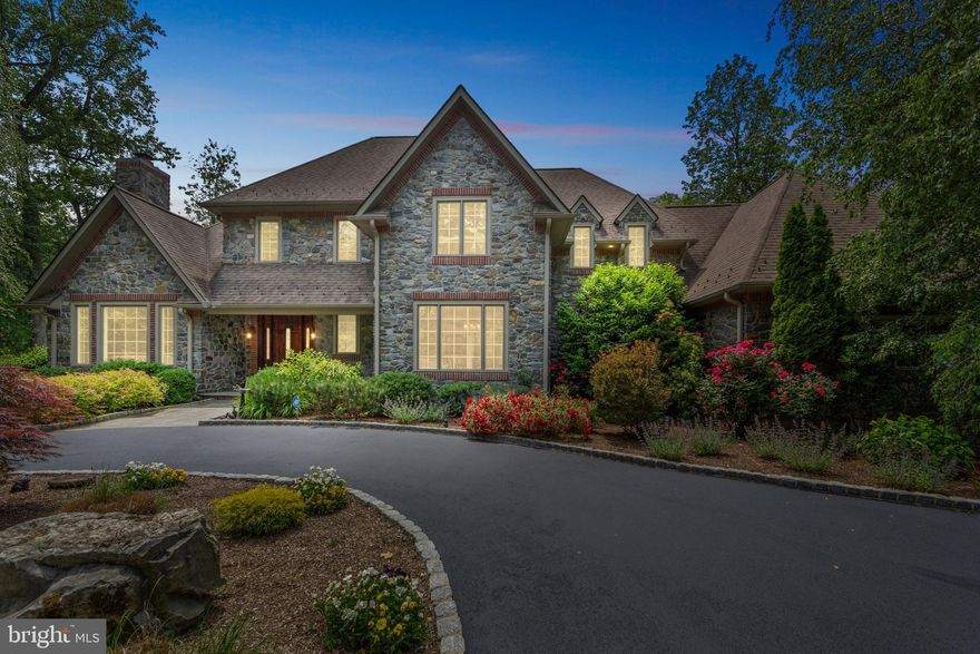 Welcome to this extraordinary manor home in prestigious Radnor Hunt—where timeless elegance meets exceptional space and versatility. With a commanding presence, circular driveway, and a floor plan designed to impress, this home offers a truly unique living experience on a 2.3-acre level lot.
Upon entering the home, you're greeted by a dramatic front-to-back foyer featuring a sweeping curved staircase and a gracious, light-filled layout. The formal living room boasts a cozy fireplace, while the dining room is elevated by detailed wainscoting and large, high-set windows that fill the space with natural light. The foyer includes a walk-in closet, and just beyond, the rear hall—overlooking the pool—offers an additional coat closet beside the formal powder room.
In one quiet wing of the home, you'll find a private den with custom shades—an ideal retreat—adjacent to the luxurious first-floor primary suite. This serene bedroom features a gas fireplace, tray ceiling, and dual walk-in closets. The elegant primary bath includes separate vanities, a water closet, a footed oval soaking tub, and a large shower with built-in seating. A private exit leads directly from the bathroom for easy access to the outdoor living area—perfect for transitioning from a refreshing swim to a relaxing shower.
At the heart of the home is the expansive family room with a raised-hearth stone fireplace and scenic views of the estate-like grounds. The family room connects to the kitchen through two separate doorways, offering seamless flow for entertaining. The kitchen features pecan-toned wood cabinetry, granite countertops, a generous center island, bar and wine display area, under-counter microwave, stainless sink, gas cooktop, double KitchenAid ovens, a new side-by-side refrigerator, dual pantries, a built-in desk, and utility closet. Off the kitchen are the second powder room, laundry room, and access to the three-car garage. Upstairs, the curved staircase and gallery landing lead to three spacious, carpeted en-suite bedrooms—each with tiled baths and linen closets. Rich Brazilian cherry floors continue throughout the upstairs hallway, complementing the hardwood flooring on the main level.
The backyard is truly a showstopper. A sweeping bluestone patio, partially covered by a custom retractable awning, offering the perfect setting for outdoor dining, relaxing, or entertaining. The heated pool and hot tub are surrounded by beautifully manicured grounds, providing a serene, resort-style escape right in your own backyard. This private outdoor oasis perfectly complements the elegance and scale of the interior living spaces.
A gracious open stairway from the family room leads to a lower level that lives like a second home. This expansive area includes a full kitchen, two full bathrooms, a den or office with built-ins, and an L-shaped family room with two walls of custom bookcases plus an additional seating area. You’ll also find a walk-in cedar closet, exercise room, dedicated workshop, and a game room with pool table and direct exterior access from the side of the property. This level offers remarkable flexibility—whether for multi-generational living, hosting long-term guests, or creating the ultimate entertaining or hobby space. With an abundance of closets and storage areas throughout, this stately home leaves nothing to be desired.
Set within the coveted Radnor Hunt area, known for its sprawling estates and picturesque vistas, this home offers the best of both worlds: peaceful privacy and exceptional convenience. Despite its tranquil setting, you’re just minutes from the Main Line’s most desirable destinations, the R5 train for a direct route into Center City, Philadelphia International Airport, and major commuting arteries. Plus, you're only a short drive from the charming shops, dining, and vibrant community events in the quaint Borough of Malvern. This is truly an estate that delivers on location, lifestyle, and luxury.