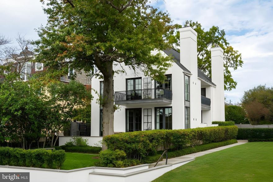 Perched high above the banks of the Potomac River on its namesake street in the heart of the Palisades neighborhood, 5431 Potomac Avenue NW stands at the apex of artistry, workmanship, and an unparalleled location. With unobstructed verdant views of the Virginia bank across, the home towers over the Capital Crescent Trail, Chesapeake and Ohio Canal, and expansive views in the winter, replaced by a kaleidoscope of vibrant shades in the warmer months. 
Envisioned in a distinct transitional style, the home’s simple stucco exterior is introduced by a geometric facade punctuated by unbroken, minimalist panes of glass. A private, zen-like front garden sits beneath a lush canopy and combines with a low-walled flagstone patio to create a sanctuary from which to take in the views. An ethereal black and white color palette carries through the light-filled, deceptively large interiors. Rich, dark stained hardwood floors complement dark framing on floor-to-ceiling windows and doors, with handsome millwork and accent lighting throughout. Two sets of French doors in the formal living room open onto the front patio, blurring the lines between indoor and outdoor living. A roaring fireplace and illuminated art niche add warmth and depth. A true functional work of art, the chef’s kitchen features frameless stacked cabinetry, glass-fronted and illuminated on the upper tier, accentuated by stunning brushed brass hardware and concealing ingenious storage solutions behind the unbroken marble slab backsplash. A comprehensive suite of state-of-the-art Wolf and SubZero appliances offers the ultimate in culinary gadgetry. An unbroken gridded wall of glass lines the main level’s substantial informal areas, comprising a generously proportioned family room and casual dining area. A private fireplace infuses coziness into the upper-level primary bedroom, which opens onto a private balcony with sweeping views from two sets of French doors. The dressing room contains extensive built-ins all neatly concealed by full-height doors, framing a large picture window. A blend of contemporary elements with classic materials and workmanship, the primary bath is clad in bold marble tile with an intricate mosaic wall behind the floating double vanity. The freestanding tub sits against a smoked mirror backdrop, and the walk-in shower is enclosed by a gridded glass door. Two additional bedrooms on the upper level are both luxuriously appointed, with one featuring a roaring fireplace and both sharing a bold bathroom. A convenient laundry room completes the level. 
Ascending to the top of the sky-lit stairs reveals two more generous bedrooms and a shared, fully-tiled bath with marble vanity. The lower level recreation room is equipped with a series of in-ceiling Sonos speakers and can be effectively utilized as a professional media room. Additionally on the lower level is a fully self-sufficient guest suite complete with kitchenette and full bath. A minimalist haven, the rear outdoor space revolves around a spectacular lap pool equipped with an automatic retractable cover, set against a linear fence and row of uplit trees. The patio consists of stone slabs with an interwoven turf grid in the quintessential Southern California style. A covered al fresco dining area greatly enhances outdoor entertaining utility, and the entire area is basked in warm ambient lighting after the sun sets. The home’s location is one nearly without peers, walkable to Claudio’s Table and Et Voila, as well as mere minutes to Virginia via Chain Bridge and Canal Road. A truly rare blend of curated interior spaces and uncompromising outdoor space, 5431 Potomac Avenue NW is undoubtedly one of Washington's hidden gems.