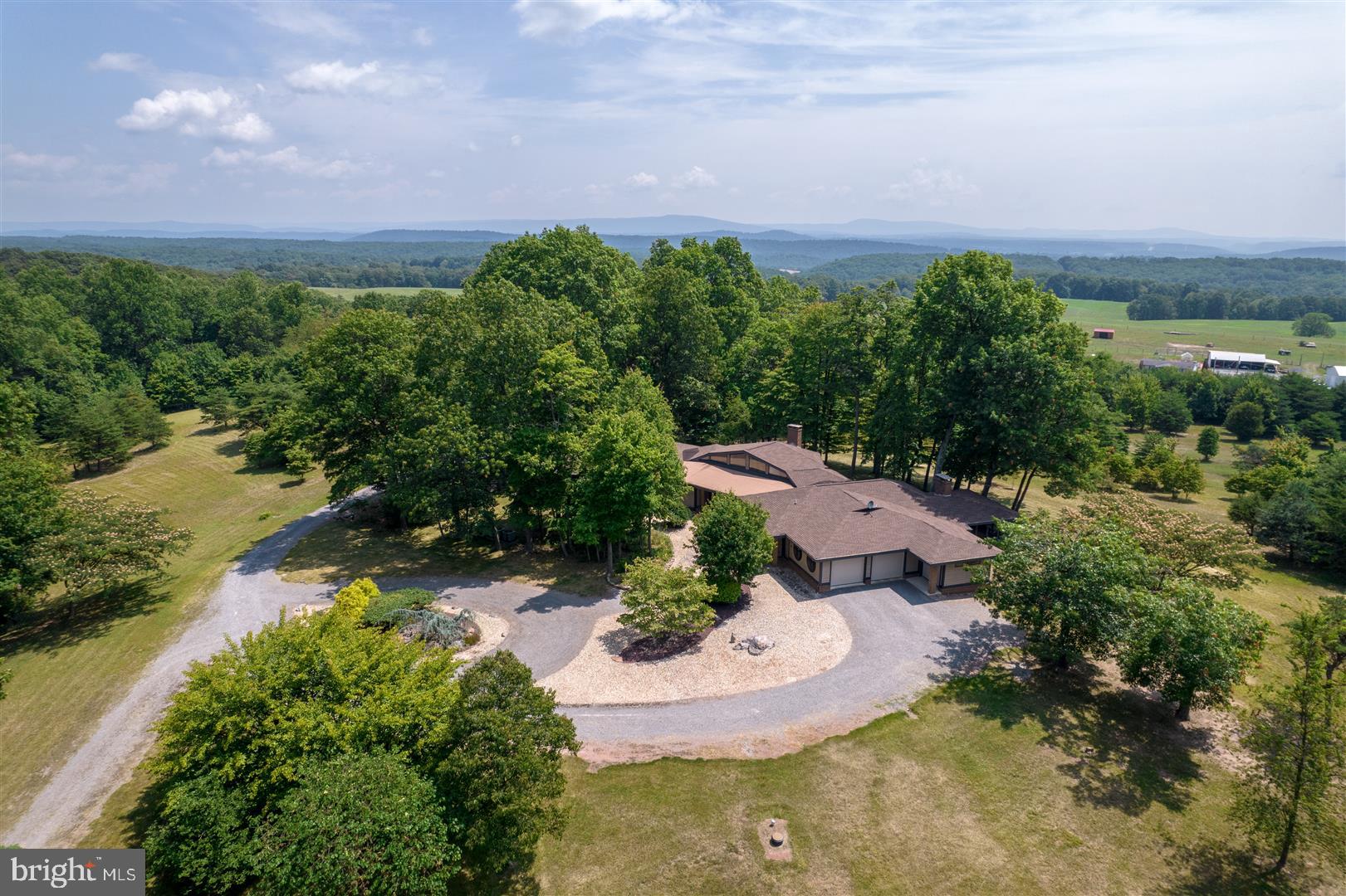 The Video Tour Link in this Listing is a Must See! ONE SUPER RARE FIND! SIZE, QUALITY & HISTORY! 240 Acres, 2 Mason-Dixon Line Marker Stones, a 4,582 Finished Sq Ft Home, a 1,184 Sq Ft Cabin, a 10 Mile View to the Potomac River, an 18 Mile Valley View, and a trail from Fort Frederick crossing the property that was used by General Braddock, are all found on this property! The Mason-Dixon Stones are most rare. One is a Crown Stone with the Calvert Coat-of-Arms on one side & the William Penn Coat-of Arms on the other. These were only placed one every 5 miles along the line. The other Stone has an M on one side for Maryland & a P on the other for Pennsylvania. This stone is placed only each mile. Not just one, but two marker stones on this property! Both marker stones are in great condition. The home is an Architectural Masterpiece! Built in 1994 with 4 bedrooms & 3 full baths, has towering wood cathedral or vaulted ceilings in nearly every room, hardwood flooring as well as custom tile flooring, gorgeous casement windows that are beautifully encased with stained wood trim. Nearly every window in the home has an incredible view. French doors exit to the wrap-around deck from the studio bedroom, the great room, the owner’s bedroom, as well as the study & the kitchen as well. The great room is definitely on point, with its wonderful acoustical design & hefty windows, your most joyful sounds will flourish as it radiates with copious amounts of natural light warming you through & through. You’ll rest well in the elegance of the owner’s suite with tasteful cathedral ceilings, a large soaking tub, hardwood floors, and french doors to the deck for a little taste of the morning sun. The kitchen has a great valley view, plenty of counter & cabinet space, a granite topped Island with a rinsing sink, & for the cook, an enormous walk-In pantry lined with cabinets matching the kitchen. The kitchen and dining area open to a peaceful study with a cozy fireplace & ample built-in shelving & cabinets for all your reading material. Just beyond the study is a nice, enclosed porch where you’ll enjoy the valley view as well as watching wildlife and all the outdoors has to offer. There are 4 recently replaced & updated heat pump units with 4 heating & cooling zones. A gas fueled boiler heats the floors throughout and can be primary or backup heat. For your vehicles there’s an attached 2.5 car garage. The 1,184 sq ft cabin was built in 1991 & has 2 bedrooms a bath & a loft area. Would be a get-away or whatever your heart desires. Well over a mile of roads & trails go throughout the property & are great for ATVs or if you feel ambitious, take a long hike. The property would also be great for hunting, especially when the property is more than large enough for those larger whitetails to stay on your land nearly all the time. Did we mention that the slope, trails, and open areas can be used for the cross-country skier in you as well! MD-68, I-70 and Hancock MD are only a few minutes away. It’s only 15 minutes to Historic Berkeley Springs. It a short drive to Antietam & Gettysburg Battlefields. Harpers Ferry & other Potomac River attractions are just a short drive as well. Furthermore, it’s only 1.5 hrs to Baltimore & 2 hrs to DC! Check it out and make this Rare Find be your Well Done!