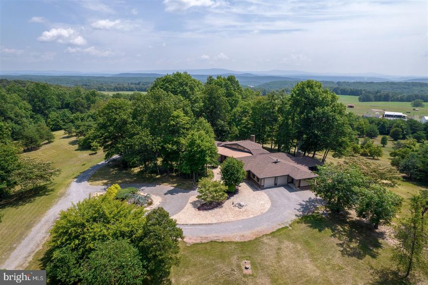 The Video Tour Link in this Listing is a Must See! ONE SUPER RARE FIND! SIZE, QUALITY & HISTORY! 240 Acres, 2 Mason-Dixon Line Marker Stones, a 4,582 Finished Sq Ft Home, a 1,184 Sq Ft Cabin, a 10 Mile View to the Potomac River, an 18 Mile Valley View, and a trail from Fort Frederick crossing the property that was used by General Braddock, are all found on this property! The Mason-Dixon Stones are most rare. One is a Crown Stone with the Calvert Coat-of-Arms on one side & the William Penn Coat-of Arms on the other. These were only placed one every 5 miles along the line. The other Stone has an M on one side for Maryland & a P on the other for Pennsylvania. This stone is placed only each mile. Not just one, but two marker stones on this property! Both marker stones are in great condition. The home is an Architectural Masterpiece! Built in 1994 with 4 bedrooms & 3 full baths, has towering wood cathedral or vaulted ceilings in nearly every room, hardwood flooring as well as custom tile flooring, gorgeous casement windows that are beautifully encased with stained wood trim. Nearly every window in the home has an incredible view. French doors exit to the wrap-around deck from the studio bedroom, the great room, the owner’s bedroom, as well as the study & the kitchen as well. The great room is definitely on point, with its wonderful acoustical design & hefty windows, your most joyful sounds will flourish as it radiates with copious amounts of natural light warming you through & through. You’ll rest well in the elegance of the owner’s suite with tasteful cathedral ceilings, a large soaking tub, hardwood floors, and french doors to the deck for a little taste of the morning sun. The kitchen has a great valley view, plenty of counter & cabinet space, a granite topped Island with a rinsing sink, & for the cook, an enormous walk-In pantry lined with cabinets matching the kitchen. The kitchen and dining area open to a peaceful study with a cozy fireplace & ample built-in shelving & cabinets for all your reading material. Just beyond the study is a nice, enclosed porch where you’ll enjoy the valley view as well as watching wildlife and all the outdoors has to offer. There are 4 recently replaced & updated heat pump units with 4 heating & cooling zones. A gas fueled boiler heats the floors throughout and can be primary or backup heat. For your vehicles there’s an attached 2.5 car garage. The 1,184 sq ft cabin was built in 1991 & has 2 bedrooms a bath & a loft area. Would be a get-away or whatever your heart desires. Well over a mile of roads & trails go throughout the property & are great for ATVs or if you feel ambitious, take a long hike. The property would also be great for hunting, especially when the property is more than large enough for those larger whitetails to stay on your land nearly all the time. Did we mention that the slope, trails, and open areas can be used for the cross-country skier in you as well! MD-68, I-70 and Hancock MD are only a few minutes away. It’s only 15 minutes to Historic Berkeley Springs. It a short drive to Antietam & Gettysburg Battlefields. Harpers Ferry & other Potomac River attractions are just a short drive as well. Furthermore, it’s only 1.5 hrs to Baltimore & 2 hrs to DC! Check it out and make this Rare Find be your Well Done!