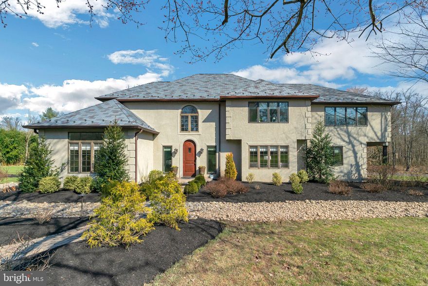 This magnificent custom-built manor captivates all with remote privacy and impeccable custom details throughout. Sprawling across 10+ acres of lush land, this five/six-bedroom, three-and-a-half-bathroom luxurious home has everything you need to live a lavish lifestyle.

Approaching the residence via the extended, meandering driveway to the grand main entrance, one is enveloped by professionally landscaped gardens and vibrant foliage in the front gardens. A custom stone walkway leads to the distinguished front door. Upon entry, guests are welcomed by a vast two-story center hall foyer adorned with glistening marble flooring and tasteful crown molding.

Directly ahead of the foyer lies an elegant living room, featuring a wood surround Ecosmart ethanol fuel fireplace, hardwood flooring, and custom built-in wooden shelving. Continuing through the foyer, discover the expansive living room at the rear of the home. This area boasts overflowing natural light, oversized windows offering sweeping views of the rear yard, bright and airy skylights, recessed lighting, a granite-topped wet bar with two wine refrigerators and cabinet storage, and direct access to the rear patio. The main floor also includes an au pair suite adjacent to the living room, comprising two generously sized bedrooms, a full bathroom with decorative tiling, a large mudroom, and a private entrance to the attached two-car garage.

Traverse the living room to encounter the gourmet chef’s kitchen, the heart of the residence. This kitchen is appointed with elegant granite countertops, high-end stainless steel appliances suitable for commercial use, abundant wooden cabinetry, a sizable center island with barstool seating, exquisitely finished tiled flooring and backsplash, a wood-burning fireplace with a brick surround, a custom milled ceiling, and a spiral staircase providing access to the sixth bedroom on the upper floor. The kitchen leads you back to the front of the home, where you can find the formal dining room complete with plenty of space to host endless dinner parties with friends and family. 

Ascend by the staircase of your choice to the second floor and discover the primary suite, meticulously appointed with an intimate sitting area, a private balcony overlooking the serene ponds and in-ground pool of the rear yard boasting a waterfront ambiance, an abundance of windows, a formal changing area, an immense California walk-in closet, and a cathedral ceiling. The spa-like exclusive ensuite bath features two stand-alone vanities, an elevated tile-surround soaking tub, and a glass-enclosed tiled steam shower. On this floor, three additional bedrooms are situated, each offering ample closet space. Rounding out the second floor is a large full-hall bathroom and a laundry room with a sink and ample wooden cabinet storage. The spacious lower level of this home features a private in-home fitness studio, copious storage options, and Bilco doors that lead you to the exterior of the property.

Nestled within the expansive backyard lies a picturesque oasis, featuring not one, but two tranquil ponds that mirror the azure sky above. A gracefully designed in-ground pool, the centerpiece of this outdoor retreat, glistens under the sun's warm embrace. This idyllic setting is further enhanced by a substantial hot tub and meticulously landscaped verdure, offering a blissful escape amidst acres of rolling green grass. A charming gazebo overlooks one of the ponds, providing a perfect spot to relax and take in the peaceful surroundings.

Situated in the acclaimed Central Bucks School District, this residence is conveniently located within a short distance of numerous golf courses, trails, restaurants, and major shopping centers. Discover the epitome of luxury living in the heart of Doylestown. Schedule your private viewing today and transform this dream home into your reality.