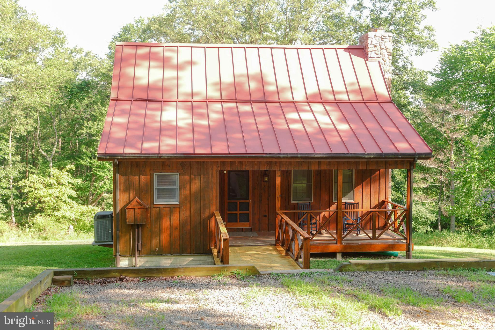 Incredible opportunity to own one of the prettiest properties in Hardy County. A sweet 2 bedroom 2 bathroom cabin meticulously kept. Main level has a great room with a floor to ceiling stone, wood burning fireplace. The primary bedroom and bathroom are on this level. Dining room with hardwood floors and cozy kitchen. There is also an bonus room that can be used as a bedroom or an office. 2nd. level has a guest bedroom and full bathroom. There is a full unfinished basement with a rough in for a 3rd. bathroom.
Just next to the house is a large stocked pond and a screened -in pond house that would be perfect for a hammock and cooler. This property consist of 3 lots and borders the George Washington National Forest. A sportsman's paradise. Hunt and fish all day long!
The two additional lots can be built on for a second home .