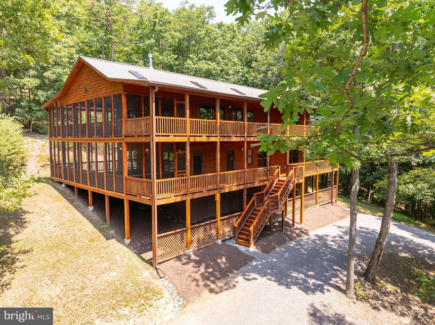 Discover this stunning 3BD/3.5BA pristine cabin/lodge nestled on 7.56 acres in the scenic Lost River Valley, just 100 miles from Washington, DC. Offering breathtaking mountain views, this property combines rustic charm with modern luxury, making it an ideal retreat or year-round residence. Luxury abounds with high-speed fiber optic internet, a propane fireplace in the primary bedroom, and all three bedrooms featuring ensuite baths. Top-of-the-line Mitchell Gold furnishings and most electronics convey, making this home nearly turnkey for its new owner(s).

Exceptional craftsmanship is evident throughout, with vaulted pine ceilings, Pella windows and doors, bespoke tiled showers with glass, modern iron stairwell railings, granite countertops, and maple floors. The upper level includes a modern kitchen featuring a wine fridge and Jenn-Air appliances, a living room with a stone propane fireplace, and a primary bedroom with a spacious walk-in closet, an ensuite bath with a walk-in shower and bathtub. The lower level features two private bedrooms each with ensuite baths, a sitting room/den for relaxation, a private office for telecommuting, and a laundry room with utilities. Both levels boast large screened porches, perfect for enjoying the serene surroundings.

The home is well-maintained and has seen recent upgrades, including a water softener, new HVAC in 2020, a seamless metal roof in 2021, and recent exterior house staining in 2023. Energy efficiency is ensured with 6-inch insulation on exterior walls and an instant propane hot water heater. Local amenities are abundant, with restaurants, shops, and markets in Lost River, Wardensville, and Moorefield, and convenient access to Winchester (45 minutes), Harrisonburg (60 minutes), and Washington, DC (100 minutes).

This exceptional cabin stands out among its peers, offering a blend of tranquility and modern comfort. Schedule a visit today to experience the luxury and serenity of Lost River Valley living!