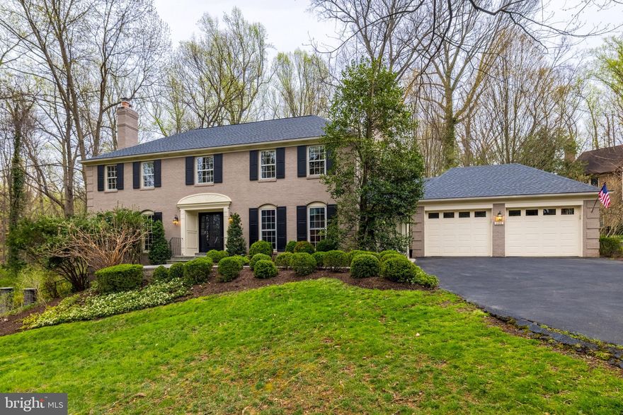 Located on a cul de sac off Old Dominion, this elegant brick colonial exudes sophistication and refinement, featuring timeless design elements and a spacious backyard offering privacy rarely found in McLean. This four bedroom, 4.5 bath home boasts 5700 sf of living and features several premium upgrades typically found only in new construction. As you enter the house you are greeted by a gracious foyer with both a large coat closet and a powder room. To the left are a living room and dining room bathed in natural light, with floor to ceiling windows that beautifully frame the picturesque landscaping. To the right of the foyer, is a detailed library with custom cherry wood walls which exude warmth and sophistication, featuring rich reddish tones, along with a smooth, natural finish, that enhances the room’s timeless beauty. The oversized designer kitchen opens to the family room, creating a dynamic social space for both cooking and gathering. The family room is adorned with beautiful wainscoting and French doors that open onto the serene garden. The kitchen features a generous top-of-the-line designer Wood Mode island and a peninsula that serves as a natural divider to the eat-in addition.  This addition is defined by a vaulted ceiling and large windows which bring the garden’s beauty inside. Surrounded by lush hydrangeas, it feels like you are eating out in the garden.  This charming space opens directly onto the elegant courtyard.The exterior of the home mirrors its interior in elegance and sophistication, offering a level of privacy that is rare in McLean. The stone courtyard and back can be accessed from the family room, kitchen, or either side of the house. A stone path, surrounded by hydrangeas, leads to a bespoke iron arch and gates on stone piers that usher you into an elegant stone courtyard. The European feeling courtyard has three blind stone arches, one of them featuring a lion’s head fountain. In addition to its refined paving and architectural details the courtyard provides a serene setting surrounded by lush landscaping. This inviting atmosphere seamlessly blends indoor and outdoor living. 
Beyond the courtyard lies a large backyard that is surrounded by parkland giving a view of endless space and privacy. The yard and the courtyard are both fully fenced in creating secure and private outdoor space for children and pets. The garage features the top-of-the-line Gladiator garage organization system, including. storage lockers, potting tables and a Gladiator floor.  A space-saving wall-mounted organization system of hooks, baskets and bins is ideal for hanging often-used items and maximizing space. There is a ceiling mounted multi-bike lift providing one-touch electric lifting and lowering to get bikes out of the way and free up valuable floor space. The second floor features 4 bedrooms and 3 full baths. The extra-large master bedroom suite is a true retreat, featuring a spacious, en-suite bath-and-a-half, and a custom walk-in closet been professionally appointed with drawers and an abundance of hanging space.  The second floor has three other bedrooms, including one with an en-suite bath and two others that share a bathroom opening to the second-floor foyer. The basement is a true extension of the living space, offering ample room for family activities and relaxation. It includes a nearly 200 square foot home gym with a rubberized floor surface that is versatile and durable. The room provides ample space for both cardio equipment and strength training. The basement also houses a 390-bottle refrigerated wine room designed to store and age wine in optimal conditions with a cooling system that maintains consistent temperature and humidity.  The basement opens onto a patio and fire pit, perfect for outdoor enjoyment.