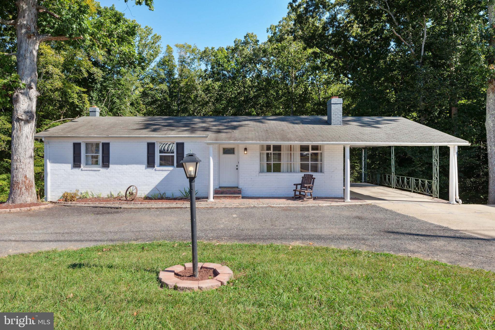 New Price!! Great News....This Home is Eligible for USDA financing (100% Financing. No Down Payment, slightly lower interest rate. ) Spacious Rancher home that sits on a 1.9 acre lot with lots of green space, backs to woods and great for parking lots of cars or work vehicles. Nice open floor plan with hardwood floors in living room, hall and bedrooms. Large country style kitchen w/island, Kitchen and Dining Area have LVP flooring. Oversized living room with recessed lights, and large picturesque window. Primary Bedroom includes two closets and a full bath with pedestal sink. You won't believe the size of the basement which includes family room w/ fireplace and access to rear lot via French doors, a utility room with built-in shelving, washer/dryer hook up and plenty of space for storage, work shop, etc., for all of your home needs. A great place to unwind, entertain, watch movies, play games or workout. The options are endless. Home has plenty of parking, including 2 carports, concrete parking pad, and circular driveway and additional parking for 7+ cars. Shed for all of your outdoor projects. Plus, New Front Door and interior doors, New Ceiling fans in all Bedrooms, Newer Stainless Steel Appliances, This home is a must see and buy!