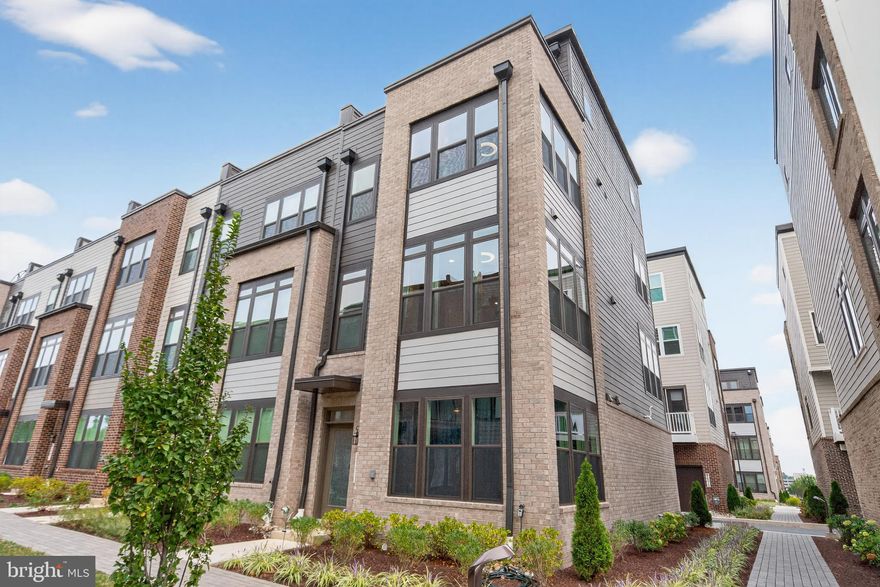 Built in 2024 by esteemed builder Stanley Martin, this luxurious 3-bed, 3-full and 2-half bath end-unit Vera townhome with rooftop deck offers elegant living in the highly sought-after Westside at Shady Grove community. Designed with both style and functionality in mind, this home features a bright, open-concept layout, upscale finishes and custom-designed window treatments throughout. The main level showcases soaring 9-ft ceilings, recessed lighting, and glamorous wide-plank LVP floors. The spacious living and dining areas flow seamlessly into the gourmet kitchen, complete with white cabinetry, herringbone tile backsplash, stainless steel appliances including a gas cooktop and double wall oven - and a massive center island with a farmhouse sink and waterfall quartz countertop. A convenient powder room and a low-maintenance composite deck, perfect for a morning coffee, complement the main living space. Upstairs, the generously sized owner's suite includes two walk-in closets and a spa-inspired ensuite bath with a frameless glass shower, dual-sink vanity, and custom-installed towel warmer. A second large bedroom with walk-in closet, an adjacent full bath with tub/shower combo, and a laundry closet complete this level. The penthouse level is a true retreat with a versatile flex space for rec room, kids' playspace, or the ideal spot to entertain guests via the wet bar, beverage fridge and direct access to the stunning rooftop deck - a magical setting for an evening under the stars! An adjacent junior suite with walk-in closet and ensuite bath is well-situated for long-term guests, office, or au pair. A light-filled ground level flex room with half bath, garage access and peaceful views of the community courtyard is ready to serve as a home gym, theater room, study or formal sitting area. The attached two-car garage includes an EV charging outlet, ceiling-mounted bike rack, and bonus storage space - plus ample street parking for guests available nearby. Tech enthusiasts will love the smart ceiling fans, smart door locks, alarm system, video doorbell, portable ice maker and two wall-mounted TVs that will convey. Enjoy all of the resort-style amenities this community has to offer including a pool, fitness center, clubhouse, tot lots, dog park, and future community garden. Located just blocks from Starbucks, CVS, restaurants, and grocery stores. An easy 0.5 mile trek to Shady Grove Metro station (Red Line), providing a direct route into DC, Arlington, Alexandria, Bethesda, Dulles airport and more, plus quick access to MD-200 and I-270. Outdoor enthusiasts will love the proximity to multiple parks such as Lake Needwood and Rock Creek, while premier shopping and dining at Crown, Rio Lakefront, and Pike+Rose are just minutes away. Don't miss this!