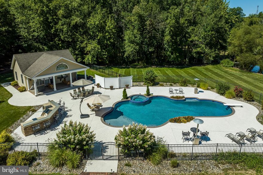 This luxury Country Estate in Doylestown, PA offers a plethora of upgrades and amenities to cater to the most discerning buyer. From its 15+ acres of land adorned with woods, stocked koi pond w/ dock, gazebo and full carriage house and pool all in a  prime location, it presents an ideal haven for those seeking an upscale lifestyle.

As you step-into the home  you're greeted by a grand vaulted ceiling foyer adorned with tiled floor with local Mercer tile accents .
This unique expanded Cape Cod offers  such versatility and open concept living area , creating an inviting space for relaxation and entertaining.  The main hallway to the ledt leads to bedroom wing and bathrooms to the right leads to the formal living room which  boasts stunning moldings and intricate details, with built in bookshelves surrounding a wood burning fireplace then to the large formal dining room complete wihth moldings and hardwood flooring. The heart of the home lies in the gourmet vaulted ceiling  kitchen, designed to delight any culinary enthusiast. It showcases, exposed barn beams with 2 skylight windows , high-end stainless steel appliances, including a range and double ovens, along with granite countertops, a center island with a breakfast bar, ample storage space, and a stylish backsplash. 
For cozy evenings, a massive  family room features a  fireplace that provides warmth and comfort. If you require a quiet space for work or study, the first floor private study/home office  offers the perfect retreat.
 Just off the  kitchen is the Florida sunroom overlooking your expansive decks and back yard oasis!

The luxurious owner's suite serves as a tranquil sanctuary with a spacious bedroom and scenic views from your private brick patio. The primary bathroom is designed for pampering, featuring a sumptuous soaking tub, a walk-in shower, and dual vanities. A large double walk-in closet provides ample storage space for your wardrobe and accessories.  The back staircase up to the private office is great for the stay at home entrepreneur.  Two large additional bedrooms and full bath found on the main level as well.
On the second floor you will find 2 Additional well-appointed bedrooms and a Jack & Jill  bathroom to ensure that family members and guests feel at home. The thoughtful layout of the residence caters to both privacy and togetherness.  There is also a bonus room for a multitude of uses that can be accessed from  the second floor office leading from the master bedroom.

The finished lower level  offers additional living space for entertaining, complete with a recreation pool table room . Outside, you'll find an oasis awaiting you. The professionally landscaped backyard is ideal for outdoor gatherings. The pool area is fantastic for outdoor entertaining and dining as it has a full kitchen seating area.  The carriage house with its own HVAC offers full kitchen, laundry & vaulted studio living area, perfect for loner term out of town guests!  
The 1600 square foot additional outbuilding offers a many opportunities for businesses , with a UPS loading dock garage door, fully carpeted and finished inside for processional use or simply storage. It also is fully heated and cooled( although not used currently).
Convenience is a key feature of this property, with local amenities, shopping centers, and dining options just moments away. Parks, schools, and recreational facilities are within a short distance, and commuters will appreciate the easy access to major highways and transportation options. The home is located close to Downtown Doylestown, Peddler's Village, and New Hope.

Don't miss the opportunity to own this exquisite property in Doylestown township , PA. Schedule a private viewing today and imagine yourself living a life of luxury in this stunning home.