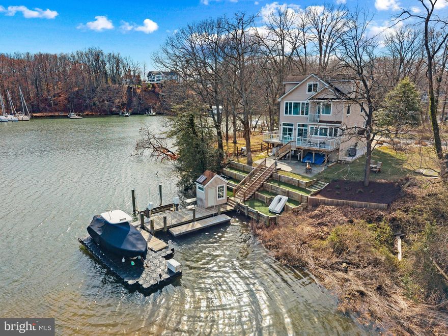 Tucked at the end of a quiet cul-de-sac on the coveted shores of Mill Creek, this exceptional waterfront retreat captures sweeping views that stretch outward to Whitehall Bay and ultimately the Chesapeake Bay, an ever-changing backdrop of light, sky, and water.

The home is thoughtfully designed to embrace its setting, with newly refinished wood floors guiding you through the main level where an open and inviting layout unfolds. The living room and kitchen are perfectly positioned to take in the water views, while a cozy fireplace adds warmth and ambiance. The spacious kitchen serves as the heart of the home, featuring a large center island with seating, generous cabinetry and countertops, ideal for both everyday living and effortless entertaining. 

Upstairs, the primary suite offers a peaceful vantage point over the water, complete with an ensuite bath, private balcony and a serene atmosphere that makes waking up here something special. Two additional bedrooms share a well-appointed hall bath, providing comfortable accommodations for family or guests. The uppermost level adds incredible flexibility, featuring a full bath, charming window seats, and an open space that can easily function as additional sleeping quarters, a playroom, or a relaxed gathering area.

The lower level, with its own private entrance, is designed as a studio-style living space complete with a kitchenette, and full bath, creating the ideal space for guests, in-laws or an au-pair.

Outdoor living is where this property truly shines. A glass-railed deck wraps around the rear of the home, offering a front-row seat to the expansive views and seamless indoor-outdoor living. Below, a stone patio provides an additional space to gather and unwind just steps from the water’s edge. The private pier is exceptionally well-equipped with two lifts, a floating dock, and a convenient storage shed, creating the perfect setup for boating, crabbing, paddleboarding, or simply enjoying life on the water.

With its premier location, versatile living spaces, and captivating views, this Mill Creek property offers a rare opportunity to experience the waterfront lifestyle at its finest. Welcome Home!