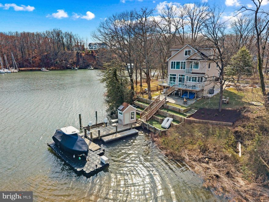 Tucked at the end of a quiet cul-de-sac on the coveted shores of Mill Creek, this exceptional waterfront retreat captures sweeping views that stretch outward to Whitehall Bay and ultimately the Chesapeake Bay, an ever-changing backdrop of light, sky, and water.

The home is thoughtfully designed to embrace its setting, with newly refinished wood floors guiding you through the main level where an open and inviting layout unfolds. The living room and kitchen are perfectly positioned to take in the water views, while a cozy fireplace adds warmth and ambiance. The spacious kitchen serves as the heart of the home, featuring a large center island with seating, generous cabinetry and countertops, ideal for both everyday living and effortless entertaining. 

Upstairs, the primary suite offers a peaceful vantage point over the water, complete with an ensuite bath, private balcony and a serene atmosphere that makes waking up here something special. Two additional bedrooms share a well-appointed hall bath, providing comfortable accommodations for family or guests. The uppermost level adds incredible flexibility, featuring a full bath, charming window seats, and an open space that can easily function as additional sleeping quarters, a playroom, or a relaxed gathering area.

The lower level, with its own private entrance, is designed as a studio-style living space complete with a kitchenette, and full bath, creating the ideal space for guests, in-laws or an au-pair.

Outdoor living is where this property truly shines. A glass-railed deck wraps around the rear of the home, offering a front-row seat to the expansive views and seamless indoor-outdoor living. Below, a stone patio provides an additional space to gather and unwind just steps from the water’s edge. The private pier is exceptionally well-equipped with two lifts, a floating dock, and a convenient storage shed, creating the perfect setup for boating, crabbing, paddleboarding, or simply enjoying life on the water.

With its premier location, versatile living spaces, and captivating views, this Mill Creek property offers a rare opportunity to experience the waterfront lifestyle at its finest. Welcome Home!