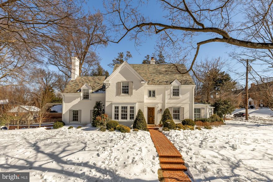 Set on a prominent corner lot in sought-after American University Park, this expanded and meticulously renovated Colonial offers five bedrooms and three-and-a-half baths, blending timeless character with refined modern living. Thoughtfully redesigned from top to bottom, the renovation preserves the home’s classic charm while introducing high-end designer finishes and hardwood floors throughout.
The heart of the home is a stunning, chef-caliber kitchen anchored by a large center island, marble countertops, and a marble tile backsplash. High-end appliances include a Wolf cooktop and double ovens, a custom-paneled Sub-Zero refrigerator, and an integrated beverage refrigerator. A custom built-in banquette creates an inviting eat-in space ideal for everyday living and entertaining.
A gracious dining room showcases original architectural moldings complemented by designer wallpaper, blending historic character with modern elegance. The main level also features a spacious living room with a gas fireplace and a sun-filled bonus room with a wall of windows and custom built-ins, offering exceptional versatility as a playroom, home office, or additional living space. A conveniently located powder room and a functional mudroom with custom cabinetry complete the main level.
Upstairs, the home offers four generously sized bedrooms and two full baths. The serene primary suite features three closets with California Closets custom built-ins and a beautifully appointed en-suite bath with custom marble tile and a large vanity. The full hall bath has been completely renovated, serving the additional bedrooms. An unfinished attic level provides excellent storage and valuable potential for future expansion.
The finished lower level includes a fifth bedroom, a full bath, and a recreation room with an additional wood-burning fireplace—ideal for guests, play, or relaxation.
Outside, the expansive corner lot offers two side yards, a spacious herringbone brick patio, and rare off-street parking with a private driveway accommodating multiple cars, creating an inviting setting for outdoor dining, entertaining, and everyday enjoyment.
A rare opportunity to own a thoughtfully expanded, move-in-ready home in one of Northwest DC’s most desirable neighborhoods.