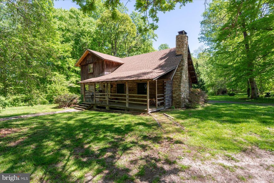 Tucked into 6.46 acres in Lothian, this custom built log cabin offers space and long term ownership pride. Crafted with exposed beams and soaring ceilings, the home centers around a large living room with a fireplace.  The layout includes three bedrooms and two full bathrooms. One bedroom is located on the main level with an attached full bath and spacious closet. The laundry room is also located on the main floor.

A two car garage provides everyday practicality, while a detached accessory building, currently outfitted with a hot tub, offers additional flexible space.  Set back from the road, the property offers a private setting while remaining convenient to Route 4. Nearby access to marinas, waterfront dining, garden centers, and shopping in Edgewater adds to the appeal, with Annapolis and Washington, D.C. also within reach.