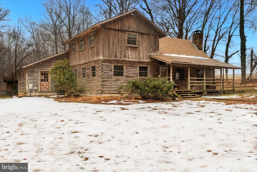 Tucked into 6.46 acres in Lothian, this custom built log cabin offers space and long term ownership pride. Crafted with exposed beams and soaring ceilings, the home centers around a large living room with a fireplace.  The layout includes three bedrooms and two full bathrooms. One bedroom is located on the main level with an attached full bath and spacious closet. The laundry room is also located on the main floor.

A two car garage provides everyday practicality, while a detached accessory building, currently outfitted with a hot tub, offers additional flexible space.  Set back from the road, the property offers a private setting while remaining convenient to Route 4. Nearby access to marinas, waterfront dining, garden centers, and shopping in Edgewater adds to the appeal, with Annapolis and Washington, D.C. also within reach.