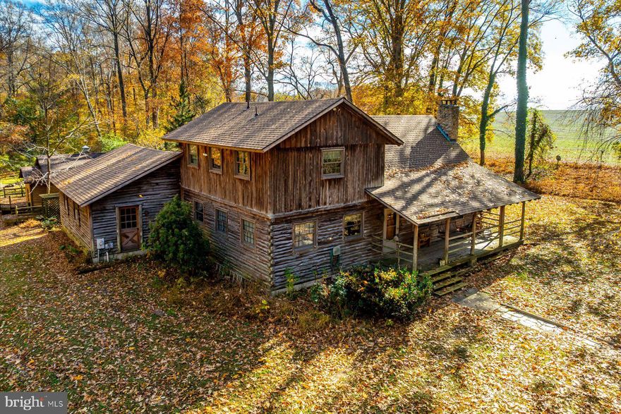Tucked into 6.46 acres in Lothian, this custom built log cabin offers space and long term ownership pride. Crafted with exposed beams and soaring ceilings, the home centers around a large living room with a fireplace.  The layout includes three bedrooms and two full bathrooms. One bedroom is located on the main level with an attached full bath and spacious closet. The laundry room is also located on the main floor.

A two car garage provides everyday practicality, while a detached accessory building, currently outfitted with a hot tub, offers additional flexible space.  Set back from the road, the property offers a private setting while remaining convenient to Route 4. Nearby access to marinas, waterfront dining, garden centers, and shopping in Edgewater adds to the appeal, with Annapolis and Washington, D.C. also within reach.