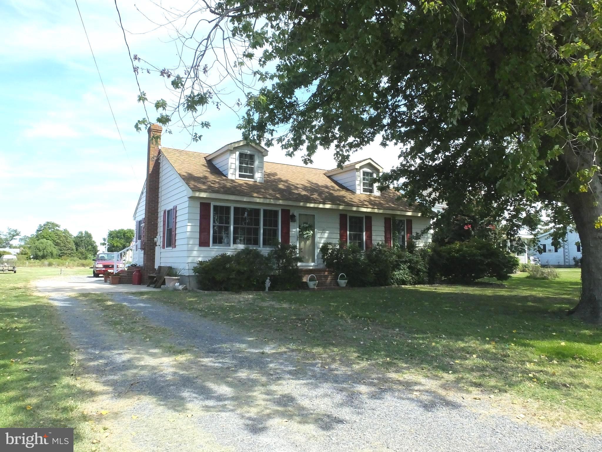 Charming Waterview Cape Cod on Hooper’s Island
Enjoy sweeping views of the Honga River and Back Creek from this well-maintained Cape Cod located just steps from PL Jones Marina. This one-owner home, built by a respected local contractor, has been carefully maintained and sits on elevated ground that has never flooded. Families will also appreciate the award-winning South Dorchester School district. Inside, the home features a beautifully remodeled kitchen with new flooring, countertops, and wainscoting. The recently renovated bathroom includes custom tile work, a ceiling heater, and a fan with a timer for comfort. Pella tilt-in replacement windows with tinted double-pane glass offer energy efficiency and easy cleaning. Lovely hardwood floors add warmth throughout. The media room is a standout, complete with built-in shelving and a desk area, illuminated by glare-free track lighting—ideal for work, study, or entertainment. Outside, the landscaped yard enhances the home’s curb appeal, while the oversized detached garage/workshop is a dream for hobbyists. It boasts 10’ insulated ceilings, 100-amp service, a 50-amp welding circuit, and an 8’x24’ remote-controlled roll-up door. Additional storage includes a full loft area and a lean-to shed with a concrete floor, perfect for tools, equipment, or seasonal items. This move-in-ready home offers the best of Eastern Shore living in a quiet Hooper’s Island setting. Don’t miss your opportunity to make it yours!