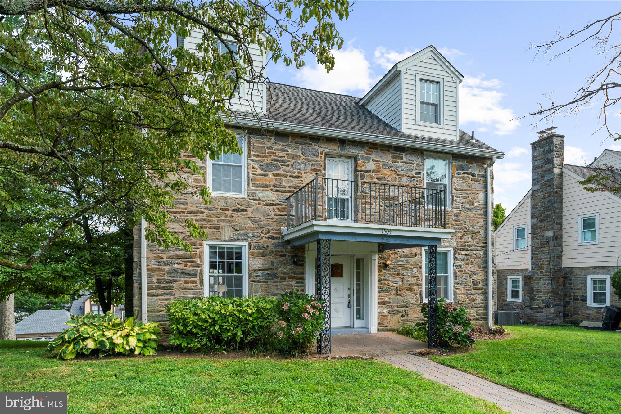 A Classic Lower Merion stone Colonial combines timeless architectural elegance with thoughtful modern updates, offering over 3 levels of functional living space filled with natural light. Set on a picturesque street. First floor center-hall foyer with solid oak hardwood floors through the first and second levels. The spacious living room features a classic fireplace and flows directly to a large entertaining deck. The formal dining room is designed for special occasions, while the kitchen connects seamlessly to a breakfast area.
Second floor boasts three generously sized bedrooms, including a primary suite with a private en-suite bathroom, a double walk-in closet, and direct access to a private balcony—the perfect spot to enjoy beautiful sunset views. Two additional bedrooms share a well-appointed hall bath.The third floor offers two more spacious bedrooms and a full bath, Finished lower level with an office area and recreation room, laundry, storage, and a full bathroom, a two-car garage, and updated mechanicals. Located in the highly regarded Lower Merion School District, this home is within easy reach of parks, libraries, shops, restaurants, and train access to Center City.