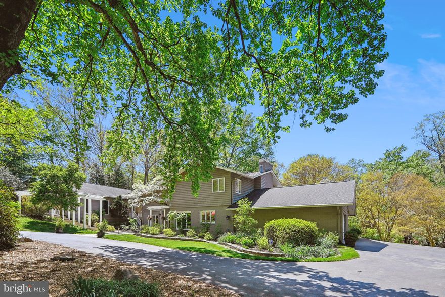 Paradise Found! A  rare opportunity to own a unique, private 2 Acre Oasis with a Guest House and Pool, Tennis court, and a stylishly updated Craftsman-style home In Vienna. This home has everything you are looking for and more...a nature lover's paradise. The circular drive invites you to the front of the home where you will find beautiful mature landscaping and gardens. The walkway leads you the front door, covered by a handsome Pergola (1 of 5 on the grounds).  Gleaming hardwood floors grace the entire main level and the upper-level hallway.  The entire home enjoys an abundance of windows providing plenty of natural light and views to the lovely grounds. The Living Room features a handsome stone wood-burning fireplace, crown molding, and recessed lighting. An Atrium door leads to the covered breezeway and Guest House beyond and a large patio door provides access to the expansive fieldstone patio. The room enjoys light from 3 windowed walls letting the outdoors in. The Formal Dining Room is an ideal spot for entertaining or daily meals. It features hardwood flooring and recessed lighting and opens to the Kitchen, Living Room and Foyer. It offers views of the terrace and the yard beyond. The Kitchen is a chef's delight with an abundance of soft-close maple cabinetry, glass tile backsplash, granite countertops and high-end stainless steel appliances including a Sub Zero fridge. The island offers prep space and additional seating while a pantry and bookcase offer even more space & functionality. It is wide open to the Family Room. The Family Room features a propane fireplace, a built-in work area and a large patio door with access to the terrace. A main level Study is the ideal spot to work from home and offers walls of built-in desk space & storage. A spacious and light-filled Laundry/Mudroom offers plenty of cabinetry and countertop space and a utility sink.  Storage hooks provide a spot for coats and backpacks and  there is access to the garage. A Powder Room is conveniently located adjacent to the Mudroom.  The Upper level features 4 Bedrooms (2 with Fireplaces and private Decks), and 2 stylishly renovated Full Baths. The  Primary Suite enjoys a Fireplace, Private Deck and ensuite Bath. Entering the Primary Bath through a sliding door, you find 2 Walls of closets providing plenty of storage. A dual sink vanity and shower occupy one half while the other side features a corner jetted tub with tree-top views and more closets.  Bedroom 2 at the far end of the hall through French doors, mimics the Primary suite in size and amenities. This Bedroom offers a Fireplace a private Deck and a Walk-in Closet. A third Bedroom offers plenty of closet space and views of the backyard. The 4h Bedroom offers wonderful views and plenty of closet space. The ancillary Bedrooms share a well-appointed renovated Hall Bath. It is composed of two separate rooms, one with a frameless shower/tub combination and the other with a dual sink vanity. A Walk-in Cedar closet is off the upper-level hallway.  Finally, across the breezeway, a charming Guest House offers plenty of lifestyle options... Whether you use it for an in-law, an au Pair, a college student, a rental, or a pool house, you will love this unique feature! The Guest House offers ceramic tile flooring and an abundance of windows suffusing it with plenty of natural daylight. The terrace is graced by a Pergola  while a private Deck provides woodland views and views of the Koi pond. It is also accessed from the covered breezeway from the main house. The Guest House enjoys an open floorplan with a Kitchenette, Living Rm/Bedroom a private Deck.  The main house enjoys a 2 car sideload garage with plenty of strage, a separate Workshop and an EV Charging Station. Outdoors 2 ACRES, a private oasis awaits. A pool/spa, an expansive terrace, tennis court (or pickle ball) or raised garden beds provide endless opportunities for hobbies or relaxing in style. Madison HS pyramid.  A rare find!!!