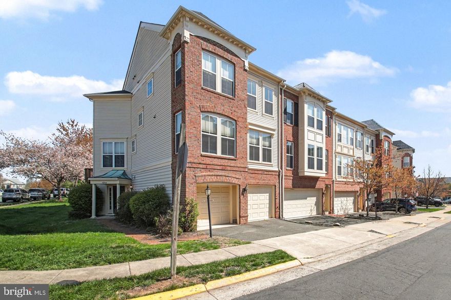 Brick front, end unit "Houdini" floor plan built by Miller & Smith in 2004 in the heart of Brambleton!  Walk to Regal Fox Cinema, Blue Ridge Grill, Onelife Fitness, the Farmer's Market, and more at Brambleton Town Center, and literally across the street from Harris Teeter, Nick's Taverna, Peet's Coffee, and many other shops and restaurants!  One block from Legacy Park with multiple playgrounds, walking trails, tennis, and volleyball!  This 2,430 fin sq ft home boasts hardwood and ceramic tile floors, a gas fireplace in the family room, lots of natural light, and a large deck overlooking the back yard.  The open kitchen offers stainless steel appliances including an upgraded Cafe refrigerator with bottom drawer freezer, a large center island with breakfast bar and Corian countertops.  The ground level den/BR4 (no closet) can also be used as a rec room or gym, and has a sliding glass door to the back yard.  Brambleton is a vibrant planned community with five swimming pools, 18 miles of paved trails, multiple parks, a library, and a golf course.  Travelers will love the being so close to Dulles Airport (IAD), and commuters can easily reach major employment centers like Reston, Fairfax, and Tysons using Routes 267, 28, 50, and 7.