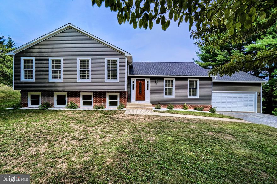 Welcome to this stunning 4-level home, featuring a beautiful white kitchen with hardwood cabinets adorned with crown molding, granite countertops with a large overhang for bar stools, a farmhouse sink, and stainless steel appliances, including a microwave range hood. The adjacent dining area opens to a spacious covered deck with stairs leading to the backyard. Enjoy the elegance of solid hardwood oak floors and stair treads on the main and upper levels.

The upper level boasts a hall bath with a dual sink vanity, a convenient laundry room, and three bedrooms, including an owner's suite with an ensuite bathroom and ample closet space. The spacious finished lower level family room features laminate flooring, is wood stove ready, has plenty of windows, color-selectable recessed lighting, a half bath, a cozy nook perfect for a home office, and a walkout to a patio and a spacious backyard with a firepit.

The lowest level is large, unfinished, but clean and dry, providing ample storage or potential for future finishing. An attached 2-car garage with a built-in overhead storage rack offers additional convenience. The roof is less than 2 years old, ensuring peace of mind for years to come.

The backyard is a peaceful oasis with fruit trees and grape vines, where deer and wild turkeys can often be seen, and the occasional American bald eagle flying overhead. Despite its secluded setting, the home is close to shopping, schools, and commuter routes, making it the perfect blend of tranquility and accessibility.