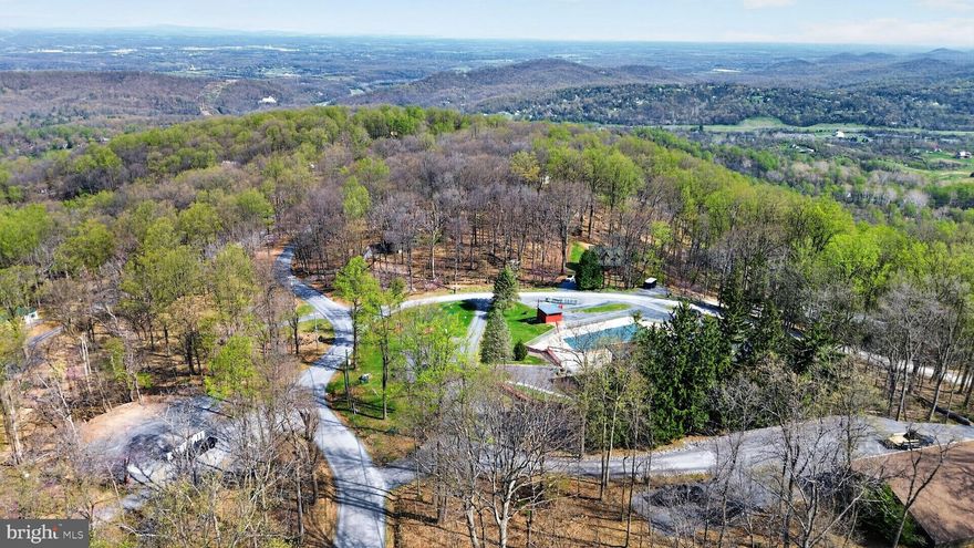 Lot 38 Windy Way offers long-range views and mature oak trees in the High Knob community of Front Royal. This well-positioned homesite provides the opportunity to design and build a custom home with flexible layout options, including potential for a walk-out basement based on the natural slope. Water and power are available at the lot. The front of the home faces south, allowing for natural light, while the rear of the property captures scenic views and shaded outdoor living potential. Located near community amenities including a clubhouse, pool, and recreation areas, this property also offers access to nearby outdoor trails and nature. The current owner is a licensed architect and is available for hire to assist with custom home design.