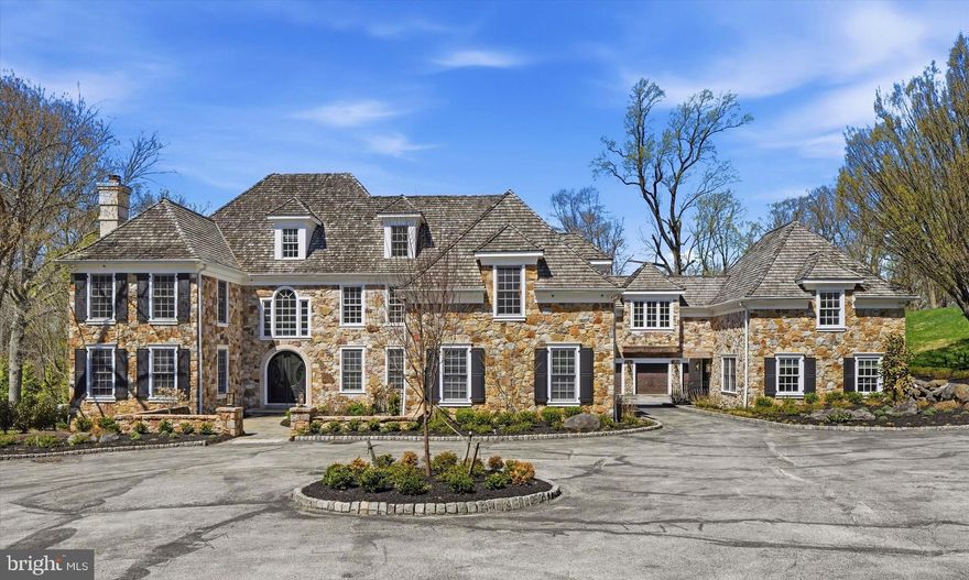 A Breathtaking Stone Villanova Estate 
7 BD  |  7 BA  |  2 Half BA  |  4.33 Acres  |  Private Road  |  3-Car Garage
Set on 4.33 acres, this property commands the quiet authority of a true Main Line estate. Impeccably reimagined for today's most discerning buyer, this fully renovated home elevates every one of its 10,000 plus square feet to the highest standard. Sequestered behind estate fencing along a private road, this magnificent stone residence stands as a testament to refined living and thoughtful modern vision.
Seven stylish, generously proportioned bedrooms, 7 breathtaking full bathrooms, and 2 beautifully appointed powder rooms offer gracious accommodations for all, with unmatched attention to detail and quality throughout.
Main Level: 
Enter through estate fencing onto a circular driveway leading to a classic stone exterior with cedar shake roof.  Grand double doors open to a two-story, sun filled grand foyer featuring a custom staircase with designer railings and wide plank hardwood flooring that flows throughout. A dedicated greeting area with seating sets the tone from the moment guests arrive. Off the foyer, a large professional home office is designed for today's executive. The formal living room is anchored by one of 3 custom marble fireplaces, while the large formal dining room overlooks the grounds. A dedicated wine closet adds a refined touch for the collector or host. The large 1st floor in-law suite features a private balcony/entrance, walk-in closet, and custom bathroom. The primary kitchen, just off the dining room, is outfitted with professional stainless steel appliances, custom range hood, waterfall marble island with seating, tile backsplash and under cabinet lighting. The catering kitchen, just off of the main, offers professional grade appliances, granite countertops, under cabinet lighting, and tile backsplash that mirrors the quality of the primary kitchen. The breakfast room features custom bench seating with views into the amazing two-story family room, complete with built in lighted shelving, custom chandelier, and panoramic views of the grounds. Rounding out the first level is a designer powder room, a dedicated dog grooming suite with shower and individual pet sleeping quarters, one of three laundry areas, and a pantry/package room.
2ND Level:
The 2nd level's unparalleled primary suite features a sitting area with marble fireplace, walk-in closet/dressing room, and a spa-like bathroom with his-and-her vanities, freestanding tub, towel warmer, and a floor to ceiling oversized marble steam shower. Three additional bedroom suites, a 2nd laundry area, and access to the guest houses' 2nd floor complete this level. 
3RD Level:
The 3rd Level is an apartment sized private retreat with bedroom, sitting areas, loft and full bathroom.
Lower Level:
The walk-out light filled lower level features a home theater with comfort seating, snack area, gym, salon with shampoo and barber chair, full wet bar with ice maker, refrigerator, and wine cooler, lounge/game area, plus an exquisite full bathroom and plenty of additional storage. 
Guest House:
The two-story guest house, with private entrance, provides a true independent living space with full kitchen, living room,  eat-in kitchen counter and 1st floor powder room.  The 2nd floor of the guest house features a bedroom, seating area, and full bathroom. 
This is not simply a home, it’s an exquisite, one-of-a-kind breathtaking Main Line estate that leaves nothing left to be desired.  This estate is in absolute move-in condition and is newly, and fully, renovated!  Far too many specialized features to list. A MUST SEE!  This is your rare opportunity to own a property of this caliber in the prestigious estate section of Villanova, where legacy properties of this character, scale and acreage seldom reach the market.  
Please present buyers qualification/BFI for showing approvals. Minimum 24 hr notice for showings.