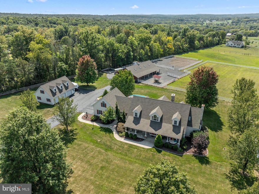 Paradise found... your equestrian retreat awaits. This beautiful farm in the award-winning Upper Perkiomen School District presides on over 7 pristine and cleared acres in bucolic Pennsburg, PA. Bring your horses or livestock and relax in your own personal oasis away from the hustle and bustle. Enter from your full front porch and through the elegant front door into a meticulously maintained, sunlit home. This scene boasts engineered hardwood floors leading to an updated kitchen with scenic views of your property and custom cabinetry, granite countertops, luxury vinyl flooring, and a bright and airy eat-in area. Relax and take in the idyllic landscape from a generously sized den with gas fireplace and sliding doors leading out to an expansive Trex deck, where you will find a fantastic entertaining space with gazebo, pool, and fenced in yard area, perfect for grilling and relaxing with guests. The first-floor primary bedroom or in-law suite with a walk-in closet and custom organization system is accessible from the den and boasts a fully updated and custom bathroom with walk-in shower, jetted bathtub, built-in cabinets, heated tile flooring, and towel warming rack. The large laundry room with cabinets and countertop along with twin pantry closets are accessible from the kitchen and provide unparalleled convenience and storage for all your home care and cooking needs. A large formal dining room, living room/office, powder room, second full bathroom, and two-car garage with 50 amp EV charger capabilities and stair access to the full basement round out the first floor. Follow the back stairwell to the second floor office, bedroom, or movie room above the garage, a recently updated living space, which has its own ductless AC system along with a full hallway of closet/storage space and an additional half bathroom. Return to the front stairs of the home and head to your second floor, which features two more spacious bedrooms with ample closets and an additional large full hall bathroom, providing great space for multi-generational living. The basement of this home has tall ceilings and is the entire footprint of the house - it could be finished to provide even more living space, if need be. Walk out the back of your home and across a lush grass yard to a full equestrian facility, approved for up to six horses or livestock, and featuring a sizeable outdoor riding ring along with white vinyl estate fencing. The barn comes complete with a large heated tackroom with half bath, seven stalls (including a broodmare stall) with dutch doors and welded mesh stall fronts, hot/cold wash stall, two frost proof water hydrants, an oversized hay loft, and two large exterior overhangs for shelter or farm equipment storage. There is also ample horse trailer parking space, an additional storage shed with chicken coop, and a dedicated cement manure pile enclosure on the far side of the barn. Incredibly well designed, the area surrounding the barn features two separated sacrifice fields with screenings gravel for when the pastures need a break. The sacrifice fields are connected to their own separate pastures - two groups of horses can be turned out without having access to each other. For your car enthusiasts, this property also features a large finished detached garage with three bays, epoxy flooring, a dry walled and floored storage area on the second floor, along with an RV parking spot to the right of the garage. The barn was reskinned with new metal siding in 2010, the roofs on the house and all buildings were replaced in 2022, the asphalt driveway was redone in 2024, and the home is wired for a whole house generator. Please see the seller's disclosure for the full list of upgrades to this home, of which there are many! Enjoy convenient access to shopping, schools, and commuter routes while still living a quiet country lifestyle. This meticulously updated and maintained farm is ready for you to make it yours - make your exclusive appointment today.