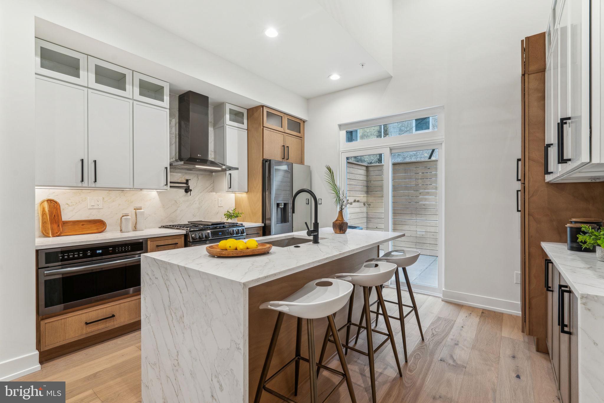 Welcome to 1104 N Bodine Street — the newest offering at The Bodine Three, a trio of architecturally stunning new construction townhomes nestled in the heart of Northern Liberties. Just a block off 2nd Street and moments from local favorites like The Piazza and One Shot Cafe, this home delivers luxury living in one of Philadelphia’s most walkable and desirable neighborhoods. Step inside and you’ll immediately notice the thoughtful layout—soaring ceilings, natural light pouring through oversized windows, and dramatic open stairwells connecting each level. Wide-plank white oak floors run throughout, complemented by a stylish second-floor catwalk that overlooks the open-concept dining space below. The lower level features extra-high ceilings, creating the perfect canvas for a home gym, movie room, or guest suite. Each bedroom is tucked away on its own private level, complete with en-suite bathrooms for maximum comfort and privacy. The primary suite is your personal escape—featuring a luxurious spa-style bath with a soaking tub and walk-in shower. Up top, a flexible fourth-floor living space offers a quiet spot to work from home or unwind with a book, and just beyond that, a spacious rooftop deck offers sweeping city skyline views. Enjoy a large private patio, 10-year tax abatement, 1-year builder’s warranty, and premium finishes throughout. As an added bonus, the seller is offering 2 year of pre-paid parking or 2 parking spots for 1 year each at a nearby lot with an acceptable full-price offer. Don’t miss your chance to own a brand-new home in the heart of Northern Liberties—schedule your tour today.