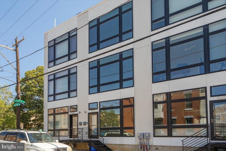 Stunning 3 BR, 3.5 bath home, in an amazing Old Kensington location w/ 2 outdoor spaces, gorgeous oversized windows throughout and 1 Car Parking! Enter into the open concept living/dining area featuring wide plank, hardwood flooring and a striking wall of windows that drench the space in natural light; a wonderful area to relax or entertain. Continue into the modern kitchen fully equipped with stainless steel appliances, white shaker cabinets, subway tile backsplash, grey quartz countertops and an island featuring a dramatic quartz waterfall top, storage and seating. Off the kitchen is a perfectly appointed half bath for everyday convenience. The backdoor leads to a rear patio, great for morning coffee and provides easy access to the parking. The second floor is home to 2 well-sized bedrooms, each with large windows and good closet space, a large laundry room with amazing storage, and a full 3 piece bath with modern, clean finishes. The third floor boasts the primary suite, complete with a walk-in closet and an en-suite bathroom with double vanity and frameless glass shower. Continue up to the beautiful and eco-friendly green rooftop deck that overlooks both the beautiful skyline of Philadelphia and the Ben Franklin Bridge. Meticulously curated, this green deck helps with rain water maintenance and offers heating and cooling efficiency within the home. The finished basement features a full bath and egress window. This space could be used as a 4th bedroom with en suite; a perfect space for guests when they come to visit. It could also be used as a home gym or office, rec room, playroom; the possibilities are endless. The house offers Smart Home technology with most lights, locks, and shades being controlled via Google Home.  2nd parking space also available for additional fee. Located just steps from Suraya, Evil Genius, Laser Wolf, La Colombe, City Fitness, the Market-Frankford El Line and all Frankford Ave has to offer!  **Photos of the home with different furniture**