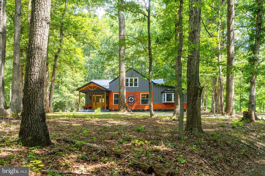 One-of-a-Kind Custom Home on 13+ Wooded Acres with Mountain Run Frontage! This beautiful barndominium was built in 2023 offering a rare blend of rustic charm and modern craftsmanship. Designed with style and function in mind, the home features a striking metal and wood exterior, durable metal roof, cathedral and two-story ceilings, exposed steel beams, and wood-slatted accent walls that elevate its character. Step inside to a spacious foyer that opens into a light-filled great room with oversized windows and a gas fireplace adorned with decorative wood surround, mantel, and raised hearth. The open-concept kitchen includes an island, pantry, and eat-in area—perfect for everyday living and entertaining. The main-level primary suite offers comfort and convenience with two story ceilings and sliding doors to outside. A primary bath offers a double vanity, soaking tub, and room for a future walk-in shower. The home is designed with a private in-law suite featuring its own entrance, a mini kitchen and living area, two bedrooms (or one bedroom and an office), and a full bath. A unique half bath with a petrified wood sink adds personality and warmth. On the upper level you'll find another bedroom with a private bath and a loft area overlooking the great room—ideal as a second living space, creative retreat, or reading nook. This home was ideal for multigenerational living space and for entertaining guests. Enjoy the outdoors from the welcoming covered front porch or explore the 13+ wooded acres that stretch along the year-round waters of Mountain Run—perfect for the nature lover, adventurer, or anyone seeking a peaceful escape. Additional features include a tankless hot water heater, whole-house water filtration system, and available broadband internet. This truly special property offers unique living with privacy, beauty, and room to grow. Come experience all it has to offer!