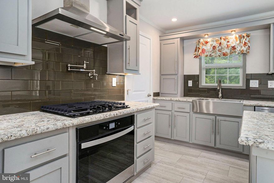 Welcome to your dream home in the highly sought-after Village Green neighborhood! This brand-new construction offers modern living at its finest, combining luxurious features with the charm of a peaceful community.  As you step inside, you'll immediately notice the open floor plan, designed to maximize space and natural light. The living area is expansive and inviting, featuring a stunning fireplace with custom built-ins that add both style and functionality. The calming, neutral paint colors throughout the home create a serene and welcoming atmosphere.  The kitchen is a chef's delight, with numerous upgrades. You'll find sleek stainless steel appliances, an island with ample workspace, and a convenient pot filler that makes cooking a breeze. The layout is perfect for both everyday meals and entertaining, ensuring you have everything you need right at your fingertips.  This unique floor plan offers privacy and comfort, with the master suite thoughtfully separated from the other bedrooms. The master bedroom is a true retreat, with large windows that let in plenty of natural light. The en-suite bathroom is elegantly designed, providing a spa-like experience at home.  Step outside to the back deck and take in the tranquil pond view. This outdoor space is ideal for relaxing with a cup of coffee in the morning or hosting summer barbecues with friends and family. The scenic backdrop adds a touch of nature to your daily life, making it easy to unwind and enjoy the beauty of your surroundings.  This home is a perfect blend of modern amenities and timeless style, offering everything you need for comfortable and elegant living. Don't miss the opportunity to make this exceptional property your own!