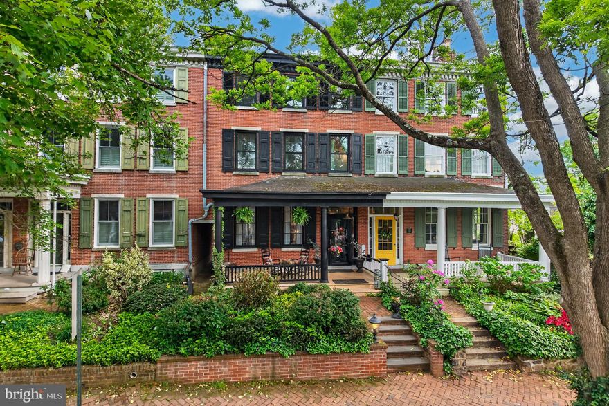 Welcome to  historic 340 W Miner St in the Portico Row section of the Borough of West Chester, characterized by elite history and architecture.  Homes in this desirable section of town do not become available often.  Timeless elegance and modern comfort come together beautifully in this 3,020 square foot townhome, just across the street from historic Mechanics Row. Built in 1848, this home is within walking distance to the center of town, with its myriad shops and restaurants. A new two car garage (with living/office space above) provides coveted off street parking! This home boasts 6 bedrooms, 3 full and 2 half bathrooms. As you enter from the quaint front porch, you are greeted by rich wood floors, that flow seamlessly throughout. Along the entryway is a built in hall tree, and just further down, on opposite sides of the hall are a half bath and the formal Living Room with a fireplace. Continue through to the spacious dining room with chestnut wood floors, followed by the heart of the home, the eat in kitchen, with slate countertops, shaker cabinets, stainless steel appliances, a large island, recessed lights and wide plank hardwood floors. Just outside the kitchen is a wet bar area with a brick wall backdrop, in addition to a half bathroom and storage/mud room.  On the 2nd level you’ll find the spacious primary bedroom suite. The large primary bathroom retreat has a clawfoot soaking tub, luxurious glass shower stall, and double sink. This level has two additional bedrooms and full bathrooms, along with the laundry room. Continuing up to the 3rd level are the final 3 bedrooms. All 6 bedrooms have their own entrance doors. Out back is a charming stone patio area with room to grill and share a meal, or simply relax and unwind. At the back of the yard is the impressive garage with ample space for 2 cars. A black spiral staircase takes you to a cozy 2nd floor that would be perfect for an at home office, home gym, or living area. It features a large room with a kitchenette and a full bathroom. Multiple windows allow for lots of natural light. 340 W Miner St can truly set the stage for a comfortable lifestyle, memorable gatherings and easy access to local amenities, parks, shops and dining options. This rare find combines both historic character and modern conveniences you’ll truly appreciate. This is your chance to own a piece of West Chester history!