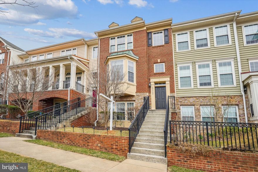 Nestled in a small upscale enclave, away from hustle and bustle,  this elegant brick & stone front townhome offers style, space, and an unbeatable commuter location in Derwood—just minutes from Rockville, Gaithersburg, and major transportation routes.  Overlooking the community’s picturesque green space and gazebo, this light-filled home exudes sophistication. High ceilings, an atrium door, picture and bay windows, and recessed lighting enhance its cheerful, open feel. Dark-stained mahogany hardwood floors and stairs, crown molding, custom trim, chair rails, and a beautifully curved newel post add to the home’s elegance and appeal.  The inviting floor plan features a sunlit living room with a bay window and custom-designed glass French doors framed by atrium windows. A cozy lounge area with a dual-sided gas fireplace and slate hearth connects the living and dining rooms, creating a warm, elegant ambiance.  The kitchen features mahogany cabinets, black granite countertops and backsplash, a window above the stainless steel sink, gas cooking, and sleek stainless steel appliances ( built-in microwave 2025).  A spacious dining room opens to a deck with wrought iron railings, perfect for relaxing or grilling.  Upstairs, the master suite boasts a walk-in closet and a luxurious bath with a mahogany double vanity, granite countertops, a separate shower, and a two-person soaking tub beneath a bright window. Two additional bedrooms share a stylish hall bath with a wood vanity, marble sink, and ceramic tile tub/shower. A conveniently located laundry closet holds a full-size top-load washer and dryer.  The above-grade lower level offers a spacious family room with a wall of three 12-panel windows, plus a second half bath with a pedestal sink. The landing features Pergo flooring and leads to an oversized two-car garage, a private driveway, and ample guest parking.  Major updates include a new roof (2020) a brand-new furnace and air infiltration system and water heater (2025),  Ideally located less than 3 miles from Shady Grove Metro and with easy access to I-270 and the Intercounty Connector (MD 200), this home offers unparalleled convenience.