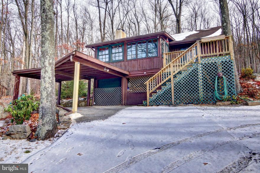 Perfect get away cabin or all year round home offering a cozy, charming and private atmosphere. Living Room has high beamed ceilings and a wood burning stove. This open floor plan has a beautiful sun room, hardwood floors, and granite counter tops. Main level bedroom as well as a bonus loft area. Sit outside and enjoy nature on the wood deck or rear patio. Large workshop in cellar. A must see!