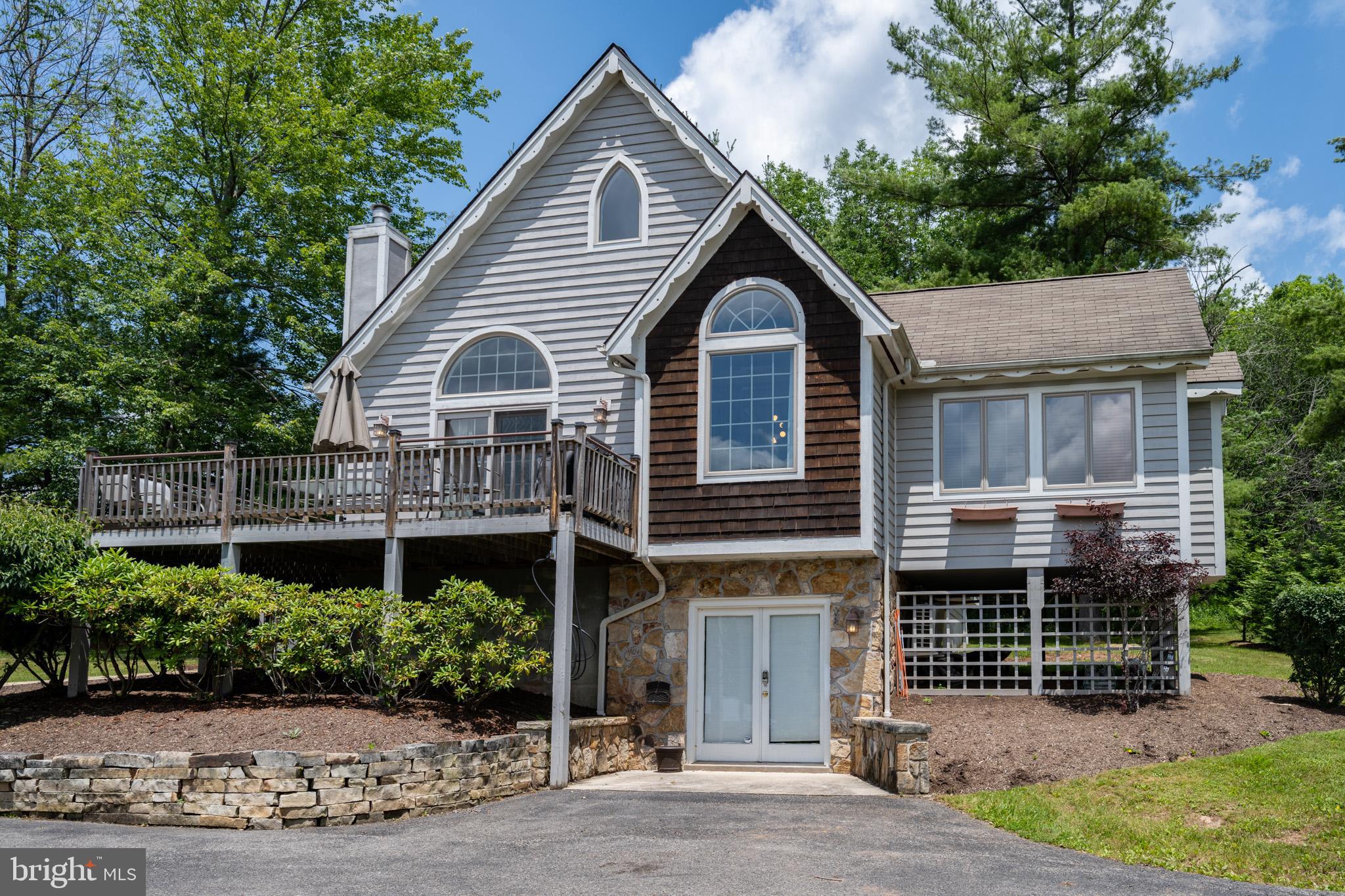Experience the ultimate in mountain-lake living with this beautifully maintained 4-bedroom, 3-bathroom home just moments from the shores of Deep Creek Lake. Nestled on a generous lot with seasonal lake views, this home offers the perfect blend of privacy, comfort, and location. Inside, you'll find an open-concept main level featuring a warm and inviting living area with cathedral ceilings, hardwood floors, and a gas fireplace — ideal for cozy evenings after a day on the lake or slopes. The spacious kitchen boasts quartz countertops, stainless steel appliances, and ample updated cabinetry, making it perfect for entertaining family and friends.
The fully finished lower level offers a second living area, game space, and easy walkout access to the driveway. Enjoy outdoor living year-round with an expansive deck, hot tub, fire pit, and room to relax and play. Electric car charger setup below deck. As an already established rental, "Captains Cabin", this is the perfect opportunity whether you're looking for a personal escape, or an investment property. Don’t miss out – schedule your private tour today!