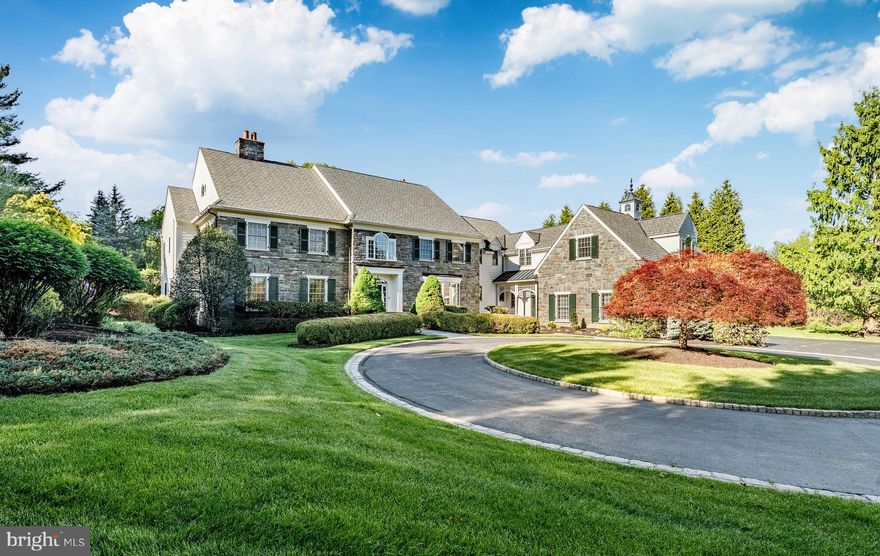 Situated in the Radnor Hunt on a 2.2 beautifully landscaped lot with a sweeping circular driveway, this timeless stone-and-Hardie-board sided residence blends stately elegance with warm, inviting charm. From the moment you arrive, the manicured grounds with mature trees, and striking curb appeal create an unparalleled sense of arrival. The stunning exterior showcases traditional craftsmanship from a bygone era and reminiscent of earlier Main Line estates with a stately stone façade, custom wood shutters and multiple gabled rooflines, highlighted by an illuminated copper-topped copula, which together result in uncompromised character and sophistication. The expansive property offers a private retreat-like setting, complete with lush lawns, irrigated specimen plantings and tranquil outdoor spaces, including a large terrace, perfect for relaxing and hosting guests alike. The interior is equally remarkable, with thoughtful architectural details, extensive millwork, including wainscotting and crown mouldings, and exceptional craftsmanship creating a sophisticated and inviting main level, designed for both elegant entertaining and everyday living. A dramatic two-story foyer with a lovely turned staircase, accented with Palladian windows sets the tone upon entry. The formal living room features an attractive wood-burning fireplace and deeply set windows that fill the space with natural light. The formal Dining Room has an oversized eye-catching bay window accented by illuminated built-in cupboards. A richly appointed study showcases custom floor-to-ceiling wood paneling, built-in bookcases, gas fireplace, and a wet bar with beverage refrigerator, creating the perfect private retreat or executive home office. The spacious step-down family room offers another fireplace and seamless flow into the fireside morning room and gourmet kitchen. The chef’s kitchen is beautifully equipped with extensive custom cabinetry, granite countertops, professional-grade appliances, oversized island, and generous prep and gathering space. A Butlerś Pantry adjoining the Dining Room and Kitchen as well as a walk-in pantry provide functionality when entertaining. The mudroom offers access to an oversized three-car garage, front and side yards, family powder and opened back staircase. The large windows and French doors throughout this main level overlook the lush grounds and integrate the homeś interior and exterior. The second floor offers an exceptional blend of comfort and functionality. A dramatic turned staircase opens to a spacious upper-floor gallery accented by front and back Palladian windows. The luxurious primary suite serves as a peaceful retreat, featuring a tray ceiling, spa-inspired bath with soaking tub, glass-enclosed shower, custom outfitted walk-in closets and Sitting Room. Four additional bedrooms are generously sized, two with en suite baths, and two sharing a Jack-n-Jill bath, all highlighted abundant closet space. The fifth Bedroom features a private Sitting Room and bath and can be easily accessed from the back staircase, perfect for an au pair or in-laws as well as visiting out-of-town family and guests. A well-equipped second-floor laundry room adds everyday convenience. Additionally, there is a walk-up staircase to the unfinished attic for expansive storage opportunities along with the unfinished basement. The property is easily accessible to popular shopping and dining options along the Main Line, quaint downtown Malvern and West Chester. Easy access to commuter rails servicing Center City with Paoli Amtrak service to NYC and D.C. and points beyond. Affordable taxes and award-winning Great Valley Schools are an added bonus. Thousands of surrounding acres are eased providing amazing views and vistas, some of which offer nature preserves for every nature lover at heart. Also, in close proximity to Fox Hollow Walking Trail. A truly Town & Country at its finest awaits the next lucky homeowner!