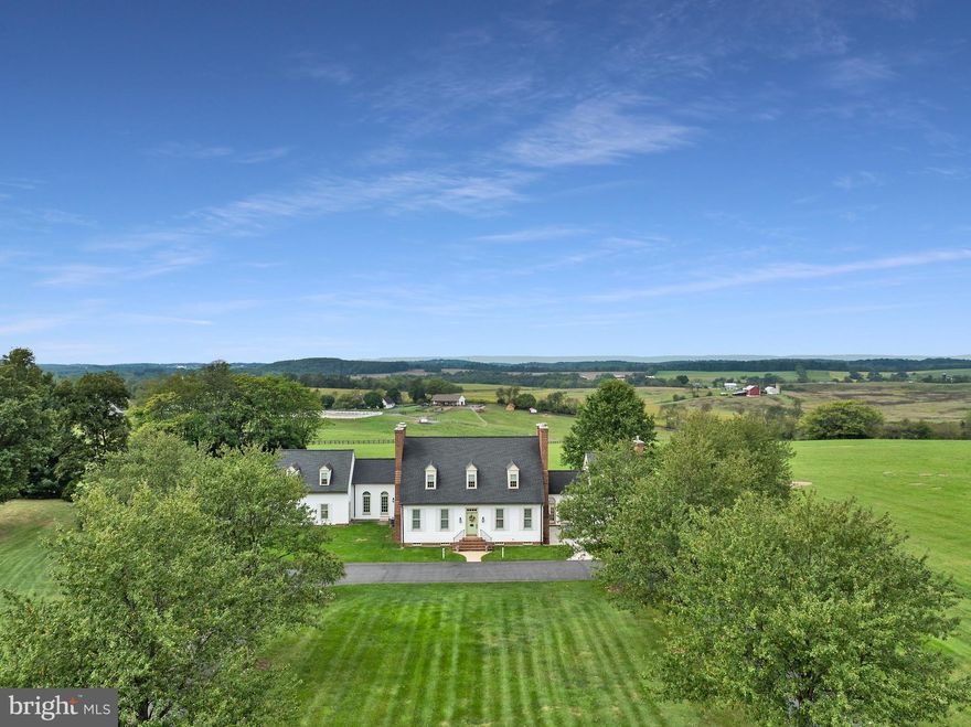 Welcome to Retreat Brown Dog Farm! A truly one-of-a-kind replica of a c. 1750 Williamsburg Colonial, this remarkable estate combines the timeless elegance of historic design with the comfort of modern systems and amenities. With over 6,320 finished square feet with 7 fireplaces, step inside the slate-floor foyer and immediately be drawn to the panoramic mountain views framed by the expansive glass windows of the family room. This stunning space features vaulted, beamed ceilings clad in shiplap, hardwood flooring, and remote-controlled window shades, creating a perfect blend of charm and sophistication. The newly renovated gourmet kitchen is a chef’s dream—complete with a gas fireplace, cooktop, stainless-steel appliances, coffee and beverage bar with drink cooler, custom cabinetry, and both a walk-in and built-in pantry. Take the kitchen staircase upstairs and you’ll find a versatile bedroom/studio/office with a half bath. The main level offers multiple inviting gathering areas, including a formal dining room, living room, ​f​amily room, and carriage house each highlighted by its own brick fireplace. A full bath and library/game room add to the functionality and flow of the home.​ Accents of unique brick floors compliment the kitchen, orangery, and floor between home and carriage house. A grand double staircase leads to the primary suite, complete with its own brick fireplace, luxurious ensuite bath with jetted spa tub and shower, and a walk-in closet. The upper level also includes one additional bedroom, with its own character—with a brick fireplace and full bath, plus a laundry room for convenience. The carriage house features a fourth bedroom and full bath, ideal for guests or extended family. Downstairs, the rustic-style basement offers a recreation area, lounging space, workshop/storage room with cabinetry, laundry sink, and second washer/dryer hookup, with walk-out access to the grounds. Nestled on almost 22 picturesque and usable acres, the property enjoys sweeping mountains and pastoral views. Continue the existing farm lease or create your own equestrian facility, bed & breakfast, or vineyard—the possibilities are endless. A custom-built deer stand is already in place for outdoor enthusiasts. An Accessory Dwelling Unit has been approved and designed by Dorman Builders for a tenant house/in-law home. Meticulously maintained and rich with detail, Brown Dog Farm is more than a home, it’s an experience you must see to believe. Come see it for yourself!