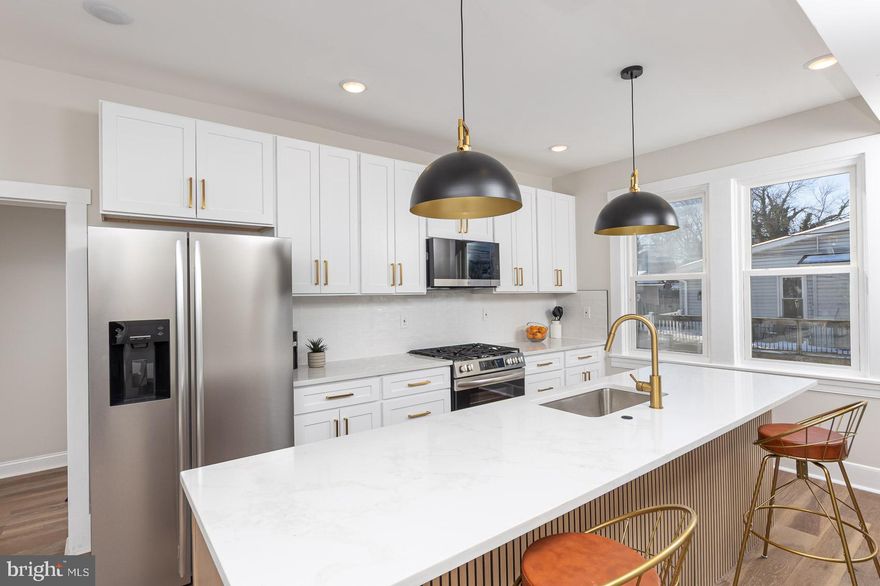 Set on a corner lot, this two-story gem is surrounded by lush grass, mature foliage, and timeless character! Brick steps leading to the elevated porch provide an attractive focal point, creating a peaceful spot to take in the sun or greet the neighborhood from your own private perch. LVP flooring and a chandelier furnish a warm introduction in the foyer and bright living room, while calming tones guide you further in. Your dining area offers a natural flow for hosting, with an adjacent gourmet chef’s kitchen boasting an a 8-foot quartz island, 42” shaker cabinetry, designer backsplash, and premium stainless steel appliances. A home office completes the main level. Upstairs, three comfortable bedrooms with ample closets including a primary suite with a fully renovated bathroom showcasing large format tile and modern matte black fixtures. A finished lower level adds functional living space for a family room, media space, or guest area. A custom built-in cabinet with butcher-block countertop and beverage fridge adds both style and convenience, perfect for entertaining or casual evenings at home. And when it’s time to unwind, the fenced backyard offers a firepit alongside a seating area just waiting to become a zen garden. Minutes from Double Rock Park, schools, shops, restaurants, and just a short drive to downtown Baltimore, this location balances urban accessibility with history, comfort, and potential. Come see how this home could embellish the next chapter in your life’s journey!