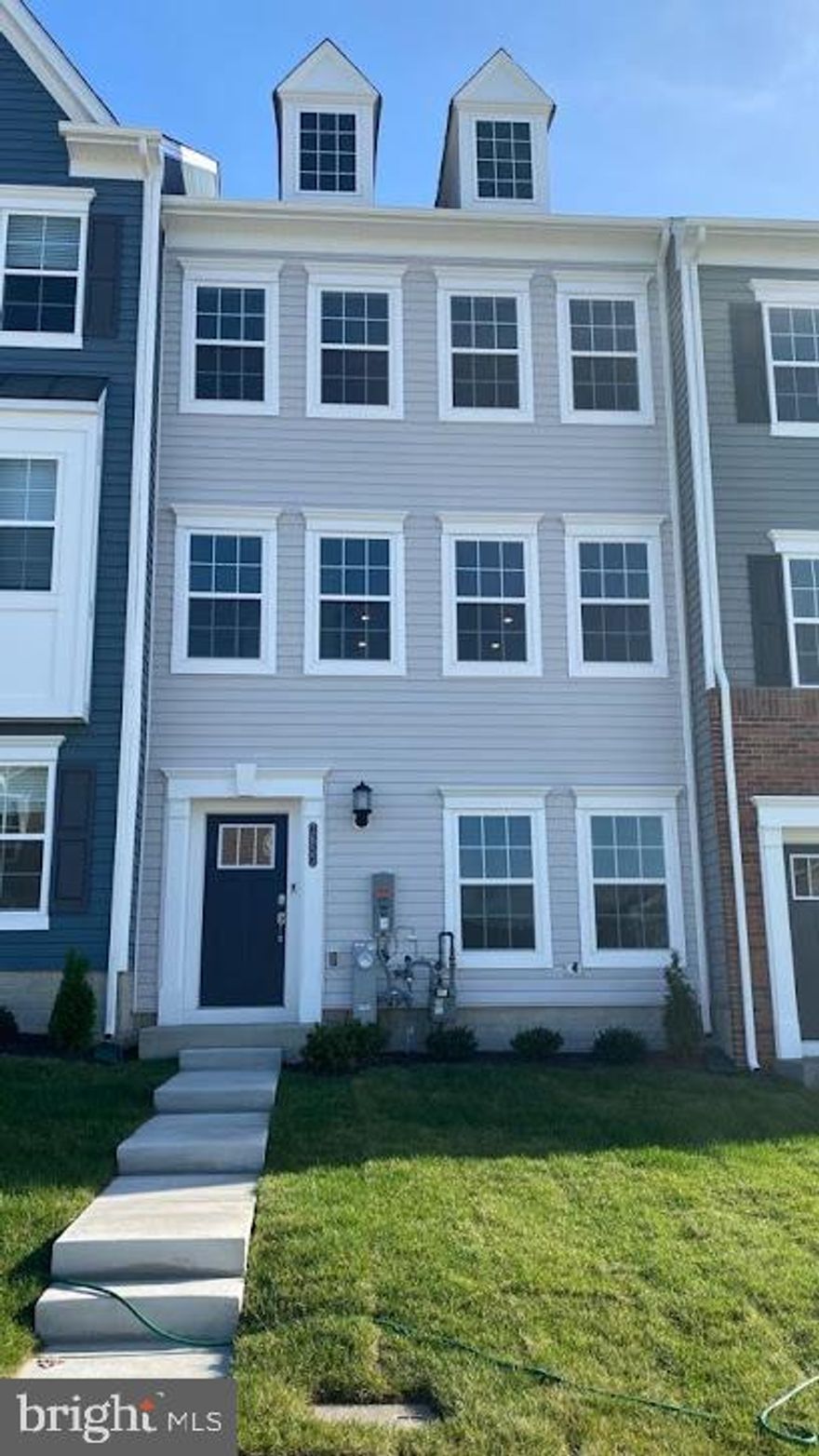 3 bedrooms, 2 full baths, and 2 half baths. A 3-level townhome with an inbuilt ring security system, video camera-equipped doorbell, appliances that include a washer and dryer, and an open deck at the first level. The first level opens into an open room with a closet and a powder room. Rear garage with a driveway that includes 6 parking spaces; Garage includes an EV charging station. The kitchen is equipped with a granite counter-topped island, an independent storage pantry, a butler pantry, and a dining area. A grand living area with options for a wall-mounted TV/Home Theater system. One powder room on the first level. Three bedrooms (with a closet in each room) and two full baths on the third level. A nice lawn with a sprinkler and hose to water the grass! Community Center with a kids' play area glorified with a splendid water fountain decoration, all within 50 feet of walking distance from home. The water/heating system is equipped with WIFI to monitor usage! Proximity to Baltimore National Pike, Social Security Blvd, US 29, and 695 Beltway. New community with proximity to Patapsco National Park, with scenic walking and biking trails overlooking the Patapsco River.