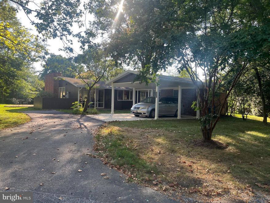 Lovely one-level home in heart of Hollin Hills, one of the areas most sought-after neighborhoods, a peaceful oasis , on a street. This 4 bd 3 bath home, with all wood flooring,  is located on a  large level lot, over 1/2 acre, with a 2-car carport, backyard patio and outdoor lighting.  It is handicap accessible, no steps, and has been expanded  to include an office area and primary bedroom with large walk-in closet and bath with shower.   Fourth bedroom has its own bath.  Hall bath with skylights.  Kitchen features SS appliances, Silestone countertops, large space for breakfast table and large open pass-thru  to dining area.  Living Rm  has wall of glass overlooking expansive level backyard and has fireplace with gas logs.  There is an attached storage/workroom that is heated and A/C.  Included on the property is a large garden shed. Home also features a whole-house generator.  Enjoy the wildlife  and walking trails  all around in this woodland neighborhood.  Ideally located, it is close to GW bike trails, beltway,  and easy commute to Pkwy, Old Town with all it has to offfer,  Pentagon, DC or south to Ft. Belvoir. Call Fran