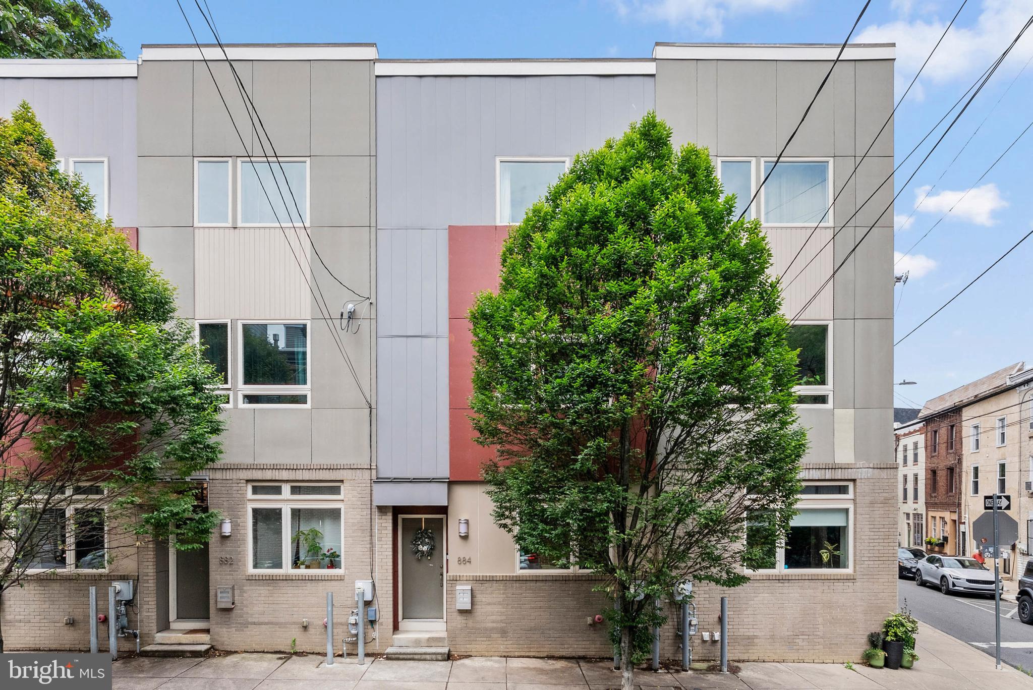 How would you like to have 1-Car parking and no HOA. Tucked away on a quiet beautiful tree-lined block in the heart of Philly's vibrant Northern Liberties neighborhood, you'll find 884 N Lawrence St. This modern, 3-story home has 3 bedrooms, 2.5 bathrooms, driveway parking, a finished basement, and multiple outdoor spaces. A towering exterior and recessed entry lead to a foyer with a coat closet inside. Hardwood floors stretch into the airy living room, where an expansive window fills the space with natural light. At the center is an open kitchen fitted with custom flat-front cabinetry, stainless steel appliances, a tile backsplash, granite counters, and a breakfast bar. A sunlit dining room with plenty of space to host guests completes the main level. Indoor/outdoor entertaining is easy with sliding doors that open to a private patio, perfect for barbecues and al fresco dining. There's also access to the driveway parking. More living space is found in the finished basement, where you can create a cozy home theater or a fun playroom. A half bathroom, laundry closet, and storage room add convenience. Up on the second level, a pair of spacious bedrooms with generous closets and bright windows flank a full bathroom. The third level is dedicated to the primary suite. There's a large bedroom boasting huge windows and two double closets, a luxurious bathroom with an extra-wide vanity and a glass-enclosed shower, and a peaceful balcony, ideal for relaxing with a morning cup of coffee. The total 2052 SF includes the finished basement. In addition to everything inside, 884 N Lawrence St earns a Walk Score of 86! Northern Liberties is a sought-after neighborhood filled with top-rated restaurants, friendly shops, and lively entertainment. Playful parks are close, and neighboring Fishtown has lots more to explore. There's also easy access to I-676, I-95, and South Jersey. Schedule your showing today!
