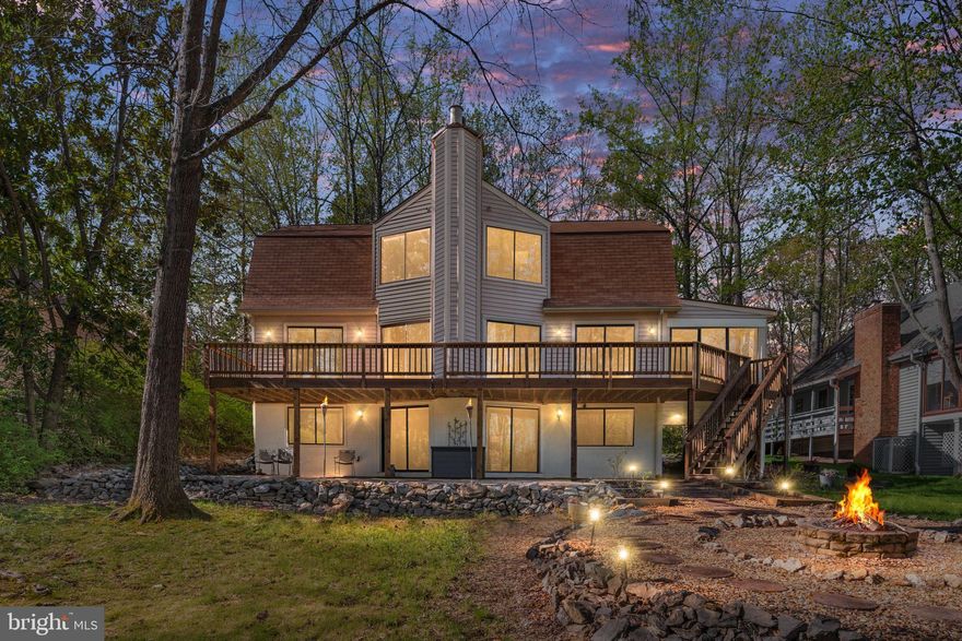 Discover this exceptional 77-foot waterfront property on ½ acre lot, located in the amenity-rich, gated community of Lake of the Woods. This well-maintained 3360 sq ft home offers four spacious bedrooms plus a dedicated office, along with 3.5 beautifully remodeled updated bathrooms on three levels of living space to relax and entertain.  The main level foyer will welcome you with the two-story Great Room, warm wood tones flow throughout the home, creating an inviting atmosphere complemented by a floor to ceiling, stunning stone fireplace. Great room opens to the spacious kitchen with SS appliances, an under the sink reverse osmosis drinking water filtering system and breakfast bar which shares the large dining area connected to the porch/sunroom, all opening to the large deck across the back of the house overlooking the Lake.  Have your morning coffee on the deck with full view of the Lake from the Primary Bedroom. Primary bathroom has a jacuzzi tub and shower on main level. Upper-level Hall overlooks the Great Room with breath-taking view of the Lake.  On this level are two additional spacious bedrooms and bathroom. Lower level boasts breath-taking Lake views from a large family room with a wet bar and undercounter refrigerator and wine cooler.  Guests will enjoy the privacy of the 4th bedroom and a large bathroom with walk-in shower. Additional room can be used as a home office or craft/additional storage room. Also, the laundry room (plenty of storage) and utility/furnace room with two hot water heaters.  You will enjoy entertaining on the large paved patio leading down to the firepit and to the dock with four boat slips.  The under-the-porch parking will accommodate a small car.  (Note there is an electric EV 2 car charger in the under porch parking area.)  Review the many amenities in addition to the Lake, a 36-hole PGA Golf Course, with pro shop and café, two Olympic Swimming pools, Clubhouse with fine-dining, Fitness Center, Pickleball and Tennis courts, nine beaches, children playcenters and parks, and more. Enjoy the tranquility and beauty of lakeside living while being just minutes away from all the amenities you need.  Don’t miss the chance to make this exceptional property your own.