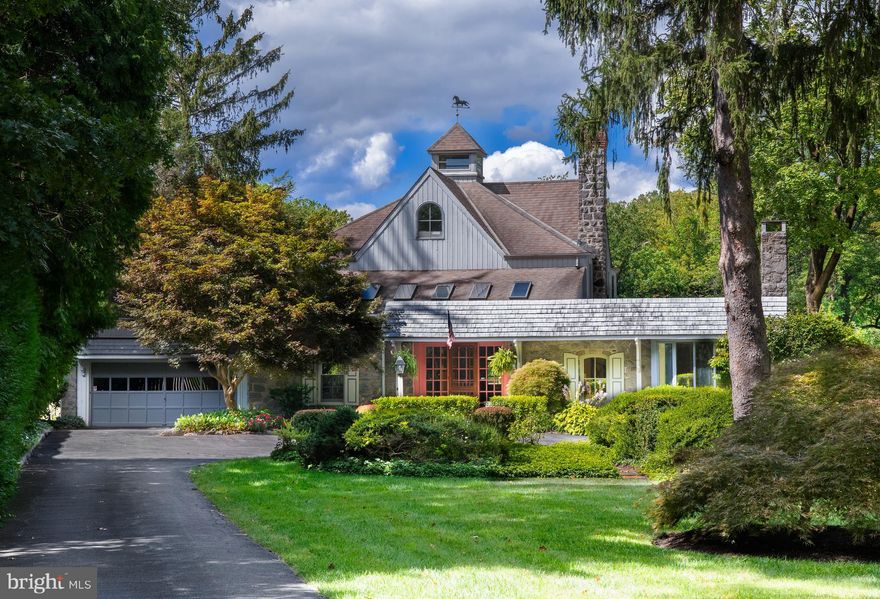Discover one of the most distinctive Radnor homes for sale — a historic converted Carriage Home nestled on over 2 private acres, offering timeless character, modern comfort, and limitless potential in the heart of the Main Line. With over 4,100 square feet of living space, this 3-bedroom, 2-bathroom home includes a loft, office, and the architectural charm of a true heritage property. Builders and visionaries alike will be drawn to the opportunity to customize or expand this exceptional residence into a legacy family estate. 
The front entry opens to a dramatic foyer anchored by an original interior gray stone wall—a striking architectural feature that reflects the home’s carriage house origins. High ceilings, long hallways, deep window sills, hardwood and parquet flooring, oversized oak doors, and interior barn doors establish a sense of craftsmanship, warmth, and timeless character from the moment you arrive.
The family room is both inviting and impressive, featuring custom built-in cabinetry and shelving that provide generous storage and display space while framing the room beautifully. A convenient wet bar, recessed lighting, warm wood floors, and an easy flow to adjacent living and dining areas make this an ideal space for everyday living and relaxed entertaining. Extending the living space outdoors, the composite deck offers a peaceful vantage point overlooking the grounds—perfect for morning coffee, evening cocktails, or simply enjoying the quiet beauty of the property.
At the heart of the home, the kitchen is bright, welcoming, and thoughtfully designed for both daily use and hosting. Custom wood cabinetry, generous counter space, and a large center island with seating create a highly functional layout, while skylights and recessed lighting flood the space with natural light. The kitchen flows seamlessly into the dining room, where walls of windows frame breathtaking views of the rear yard and pool beyond—making every meal feel connected to the outdoors.
The dining room offers a stunning setting for gatherings of any size, with panoramic views of the surrounding landscape and direct access to the porch, enhancing the home’s effortless indoor-outdoor lifestyle. The living room provides a more intimate yet equally refined space, centered around a fireplace and surrounded by oversized windows that frame lush garden views and fill the room with soft natural light.
The primary bedroom is a serene retreat, generously sized and complemented by an adjoining sitting room that offers flexible use as a private lounge, office, or reading nook. Large windows bring in abundant light and tranquil views, creating a calm and restorative atmosphere. The primary bathroom features classic tilework, a soaking tub, separate shower, and dual vanities, with a unique direct connection to the guest bedroom—allowing for a flexible and thoughtful layout ideal for guests, family, or a private secondary suite. Completing this level is an additional bedroom/office with access to the third floor loft - a versatile bonus space ideal for a home office, creative studio, lounge, or additional living area. Vaulted ceilings, skylights, and exposed beams enhance the architectural character while flooding the space with natural light.
The rear of the property opens to the home’s beloved “back 40,” where expansive green space, mature trees, and frequent wildlife sightings create a sense of complete seclusion. A newer Trex deck offers the perfect setting for outdoor entertaining, while the grounds provide ample space for recreation, relaxation, and unforgettable gatherings by the pool.